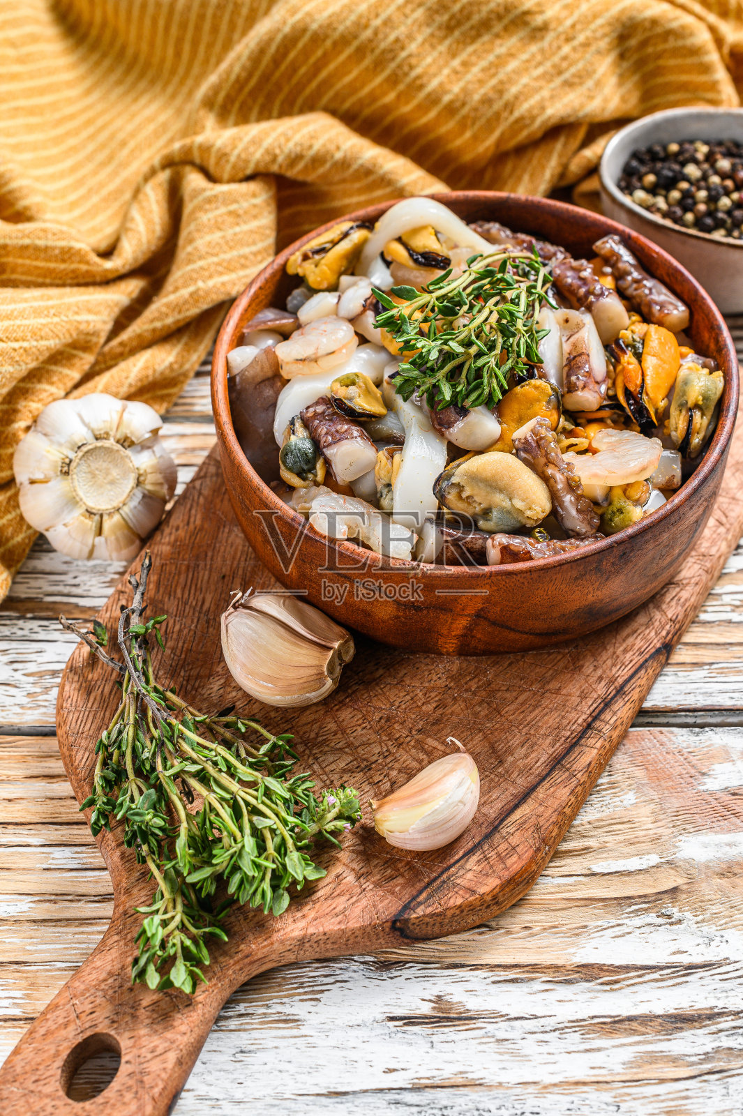 煮熟的海鲜混合在一个木碗里。贻贝、蛤、鱿鱼、章鱼、虾、对虾。白色背景。俯视图照片摄影图片