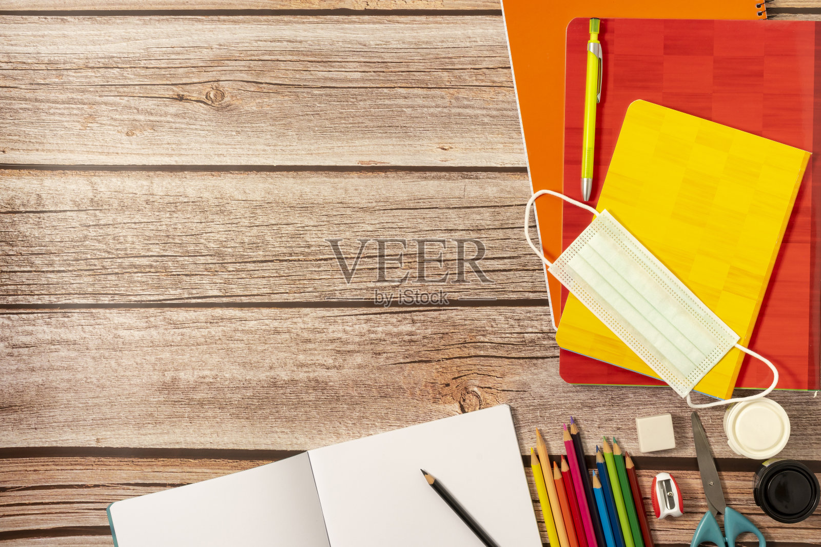 学习用品、色彩、笔记本、防疫用品等。在一个木制底座上。大流行期间重返校园的概念。照片摄影图片