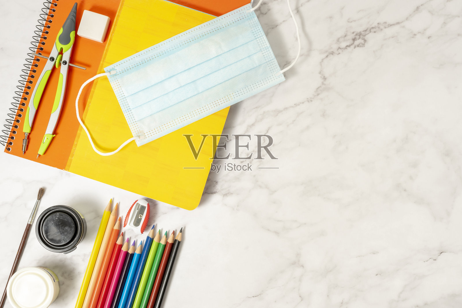 学习用品、色彩、笔记本、防疫用品等。在大理石背景上。大流行期间重返校园的概念。照片摄影图片