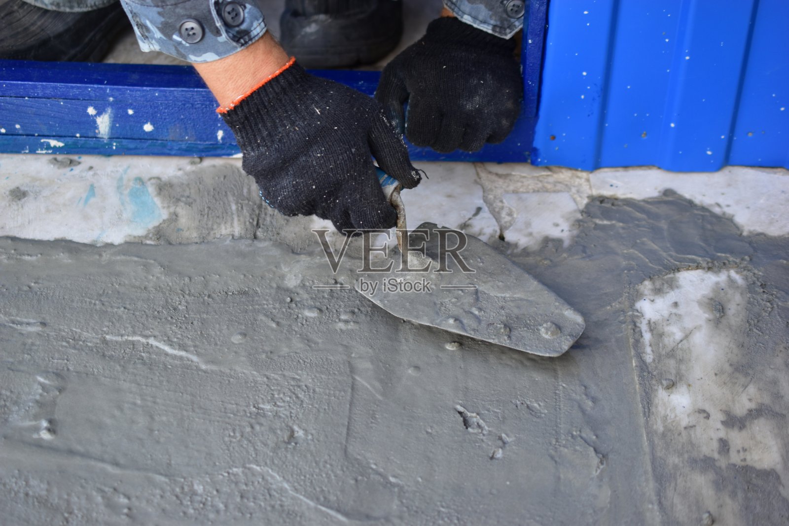 用镘刀在混凝土上刨平地面的照片摄影图片