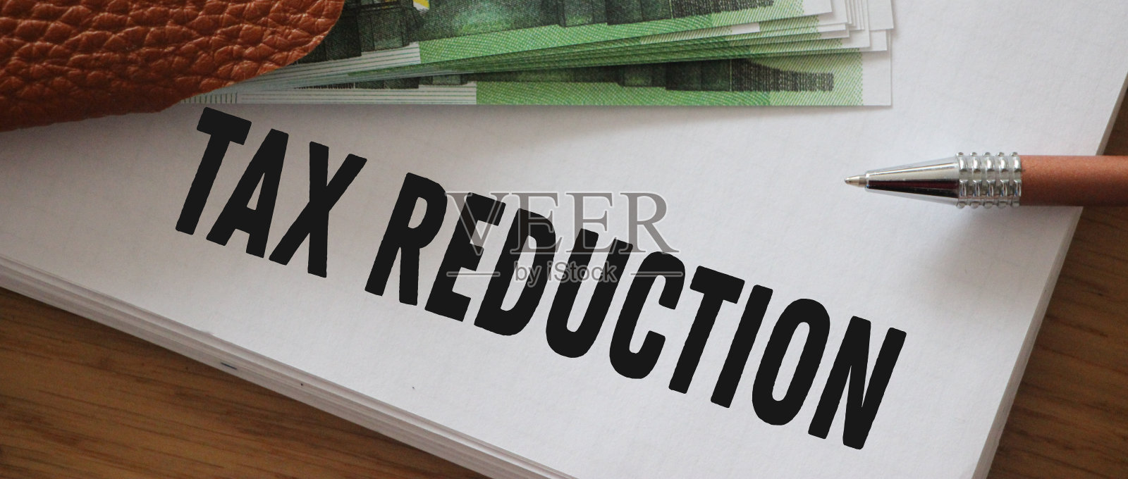 文字文字在广告页上减税，100欧元钞票。减免所得税的经营理念照片摄影图片