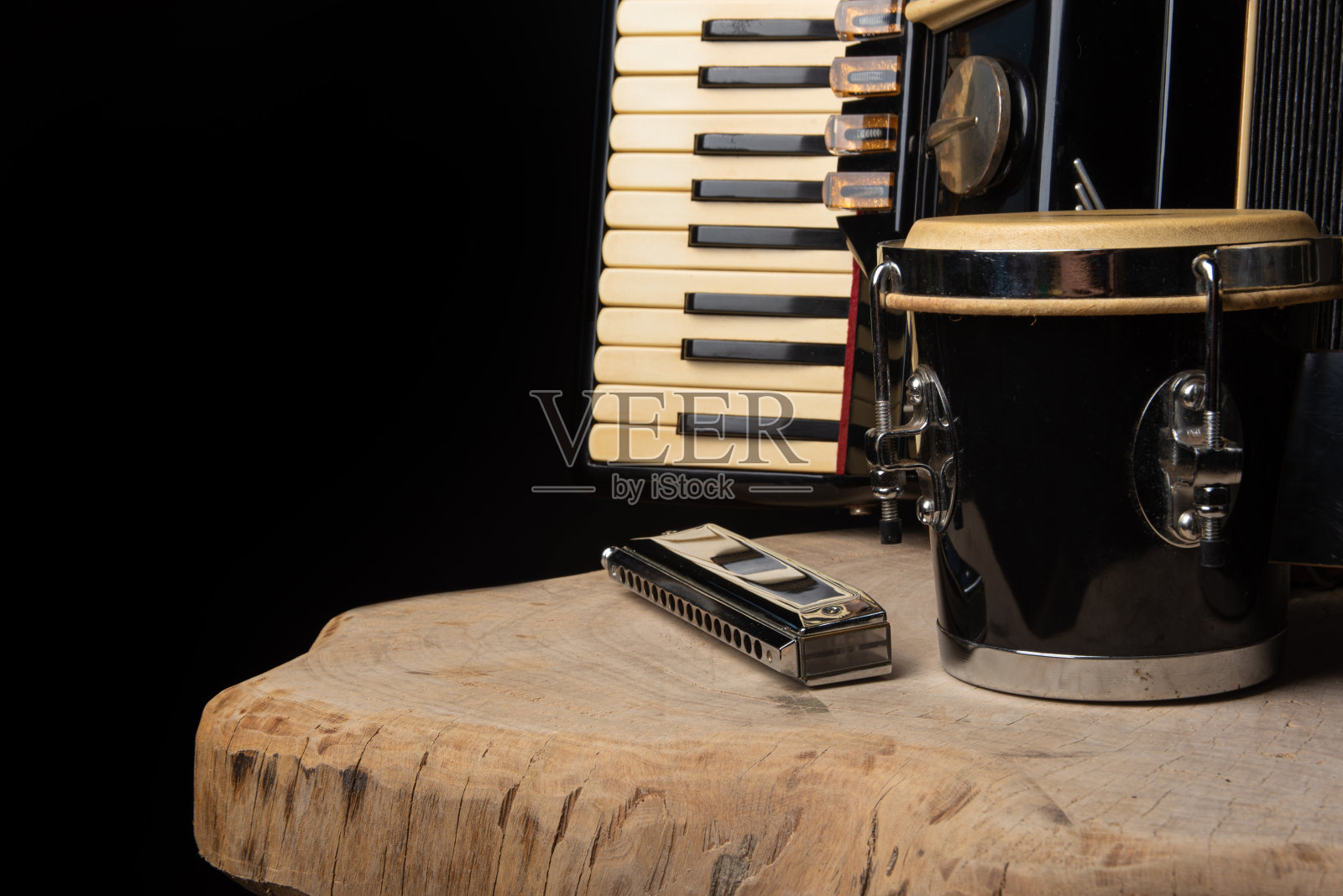 旧手风琴，口琴和烟枪在乡村木质表面，黑色背景和低键照明，选择性焦点。照片摄影图片