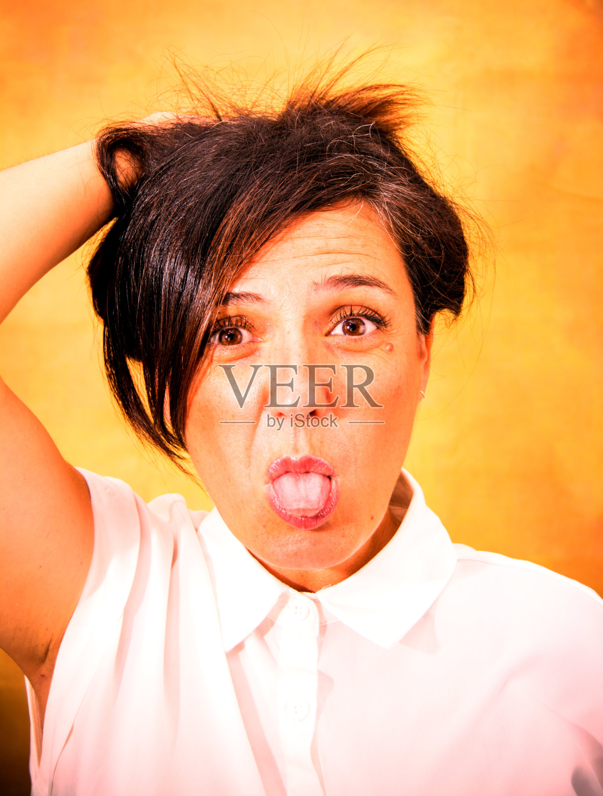 公园里有个深色头发的漂亮女人穿着白衬衫伸着舌头照片摄影图片