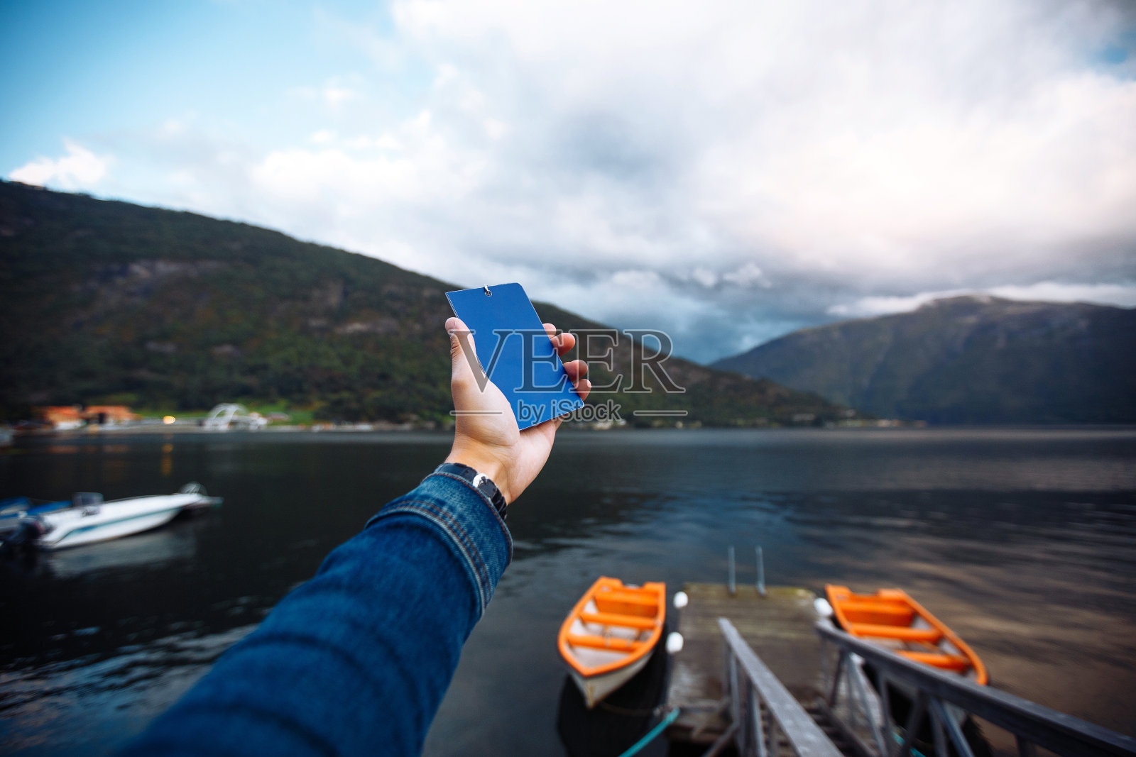 挪威宁静湖面上的一艘渔船。照片摄影图片