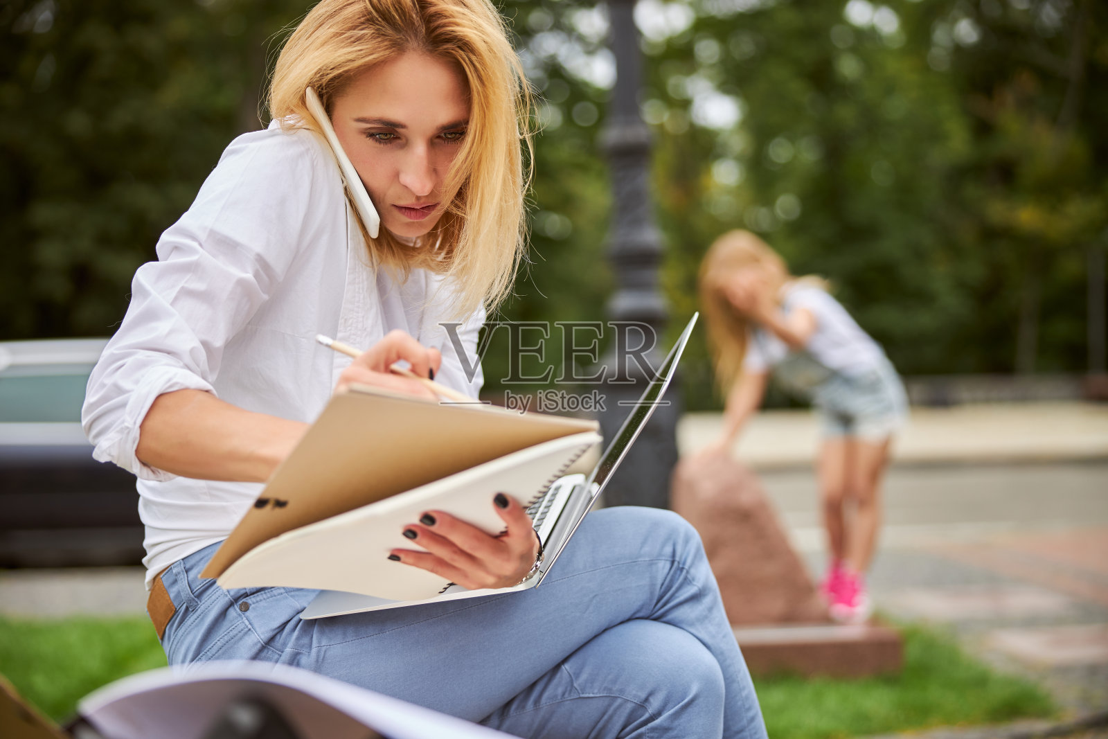 美丽的白人女性花时间在公园，而工作的文件照片摄影图片