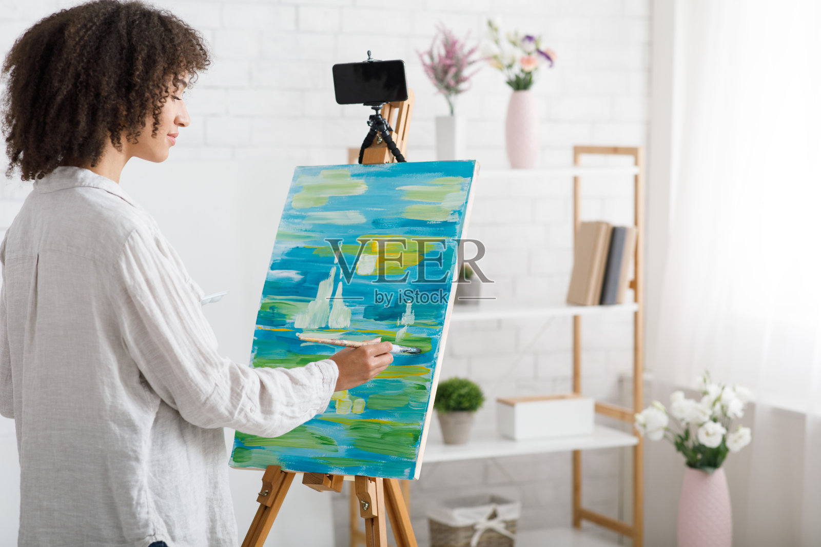 与老师在线上绘画课。女人画了一幅画，并为学生们拍摄了一节课照片摄影图片