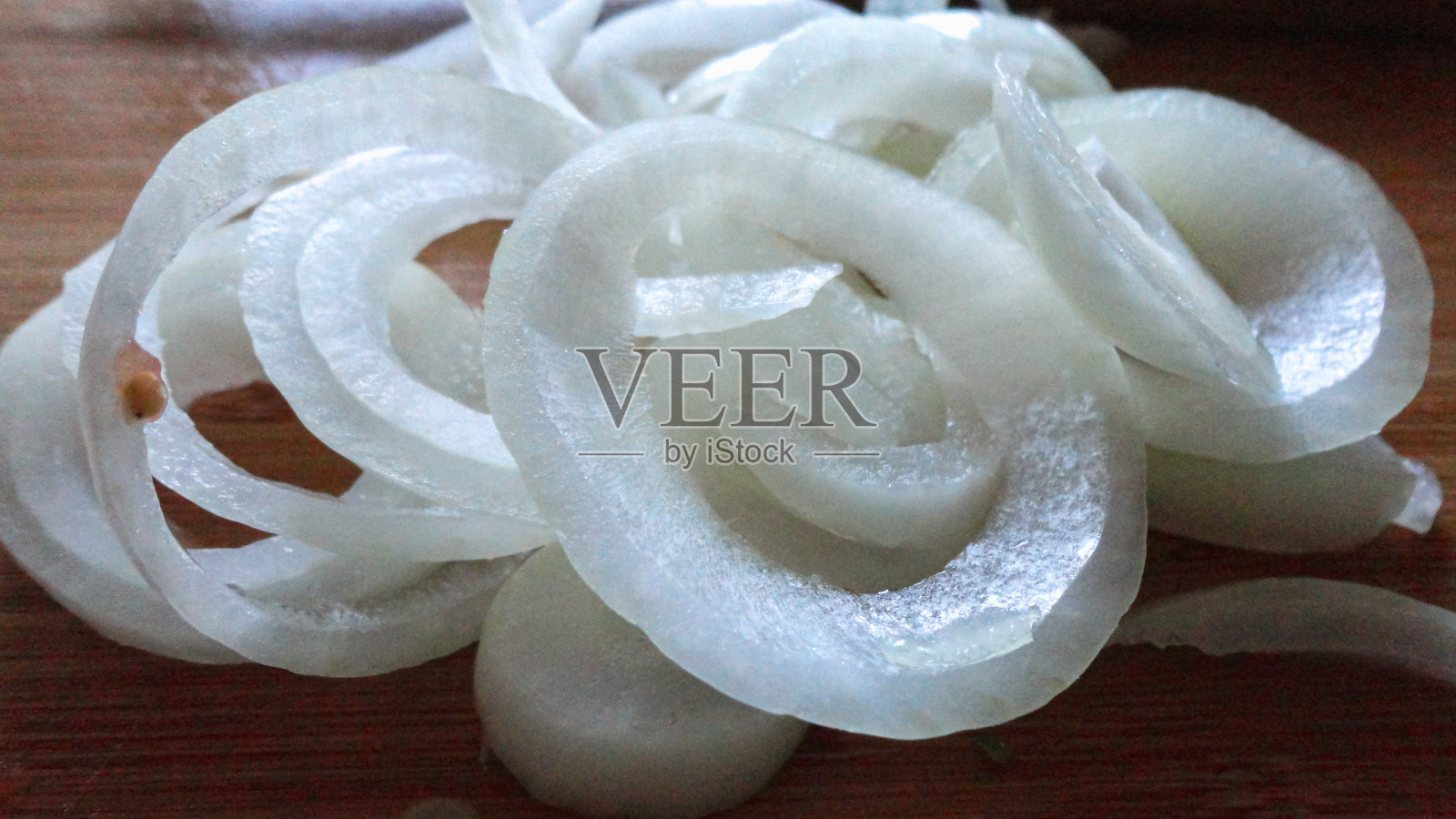 木制砧板上的有机白洋葱片照片摄影图片