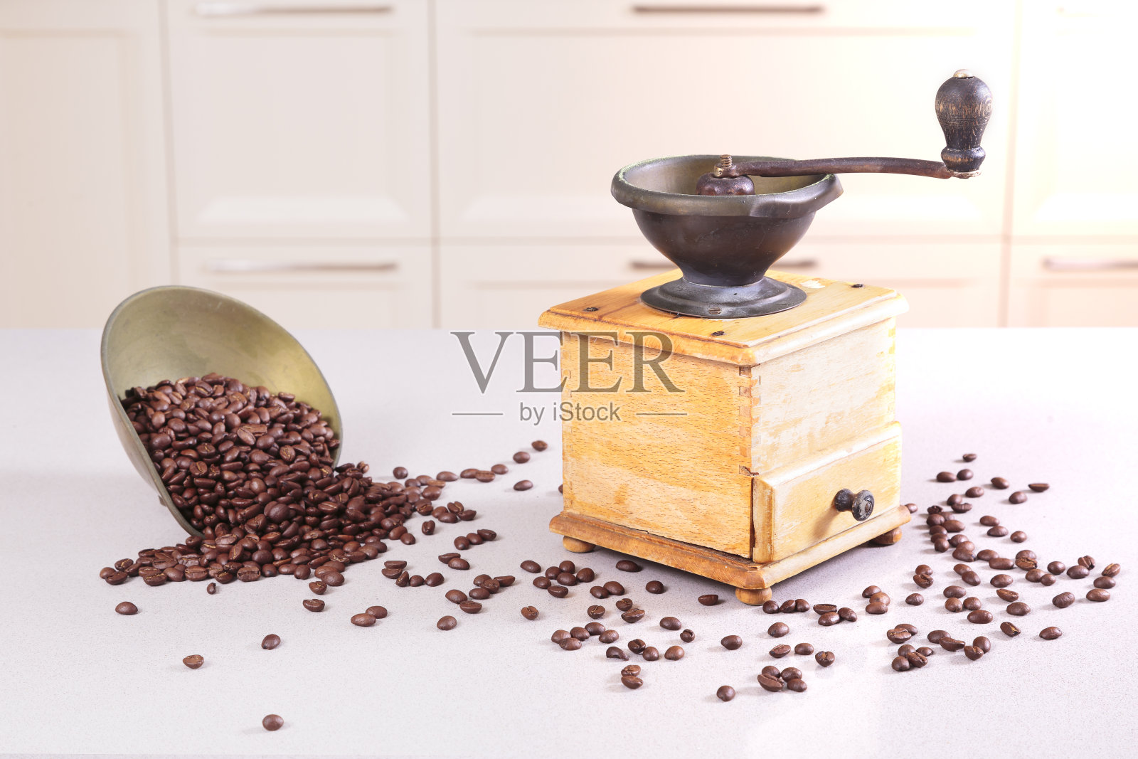古老的咖啡研磨机和一个洒了豆子的碗照片摄影图片