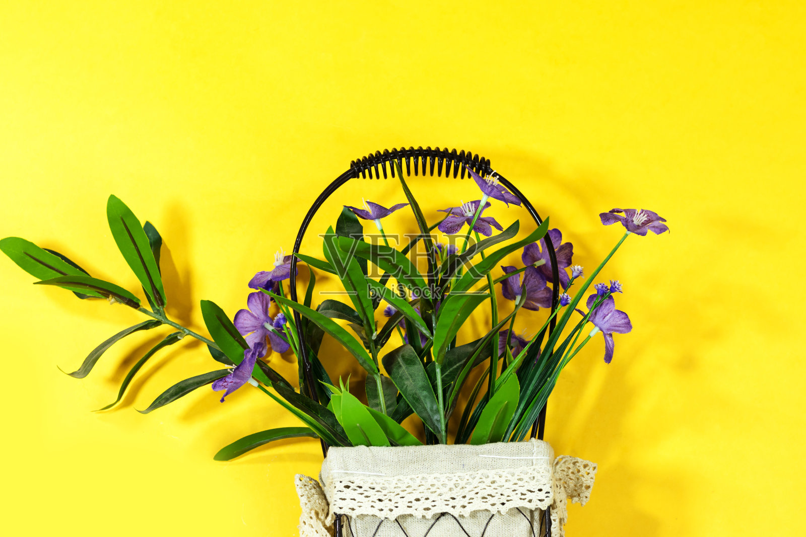 美丽的人工紫色花瓶孤立在黄色的背景照片摄影图片