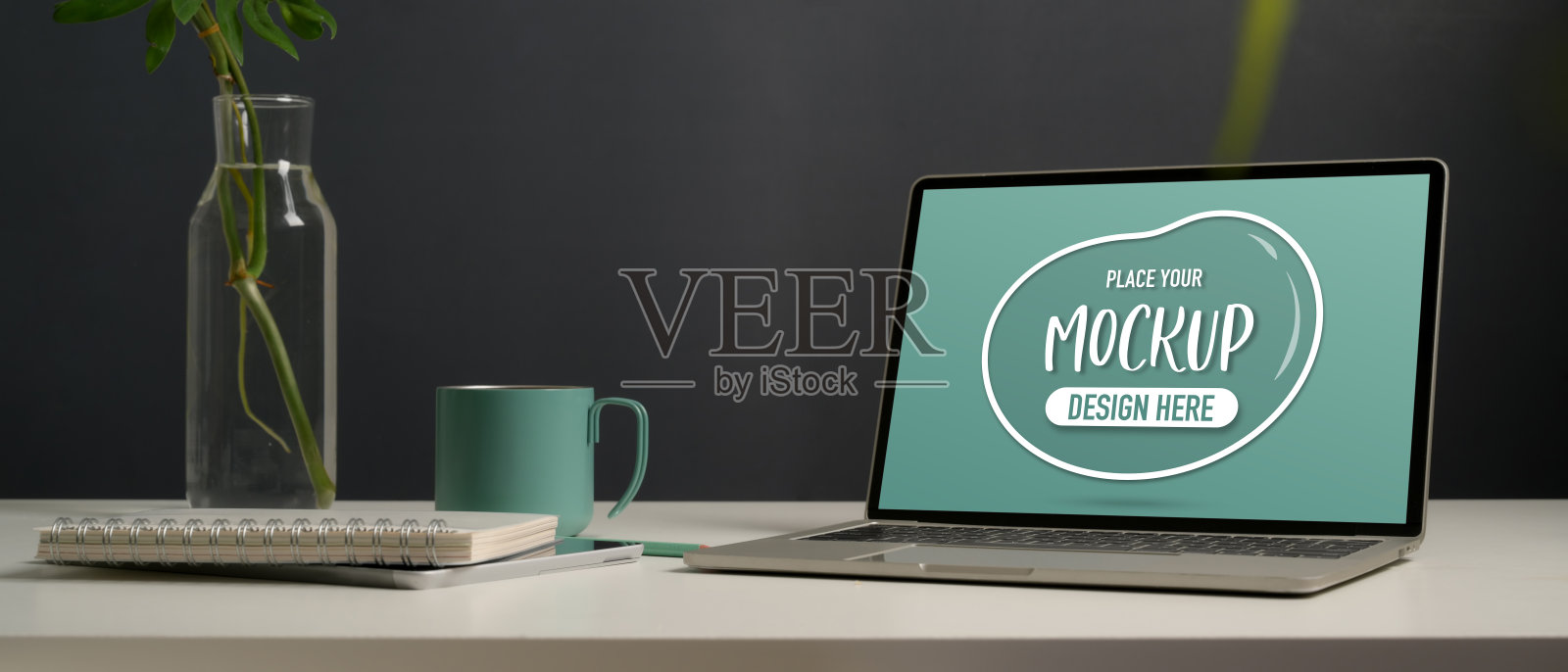 把笔记本电脑、文具、花瓶和马克杯放在家庭办公室的白色桌上照片摄影图片