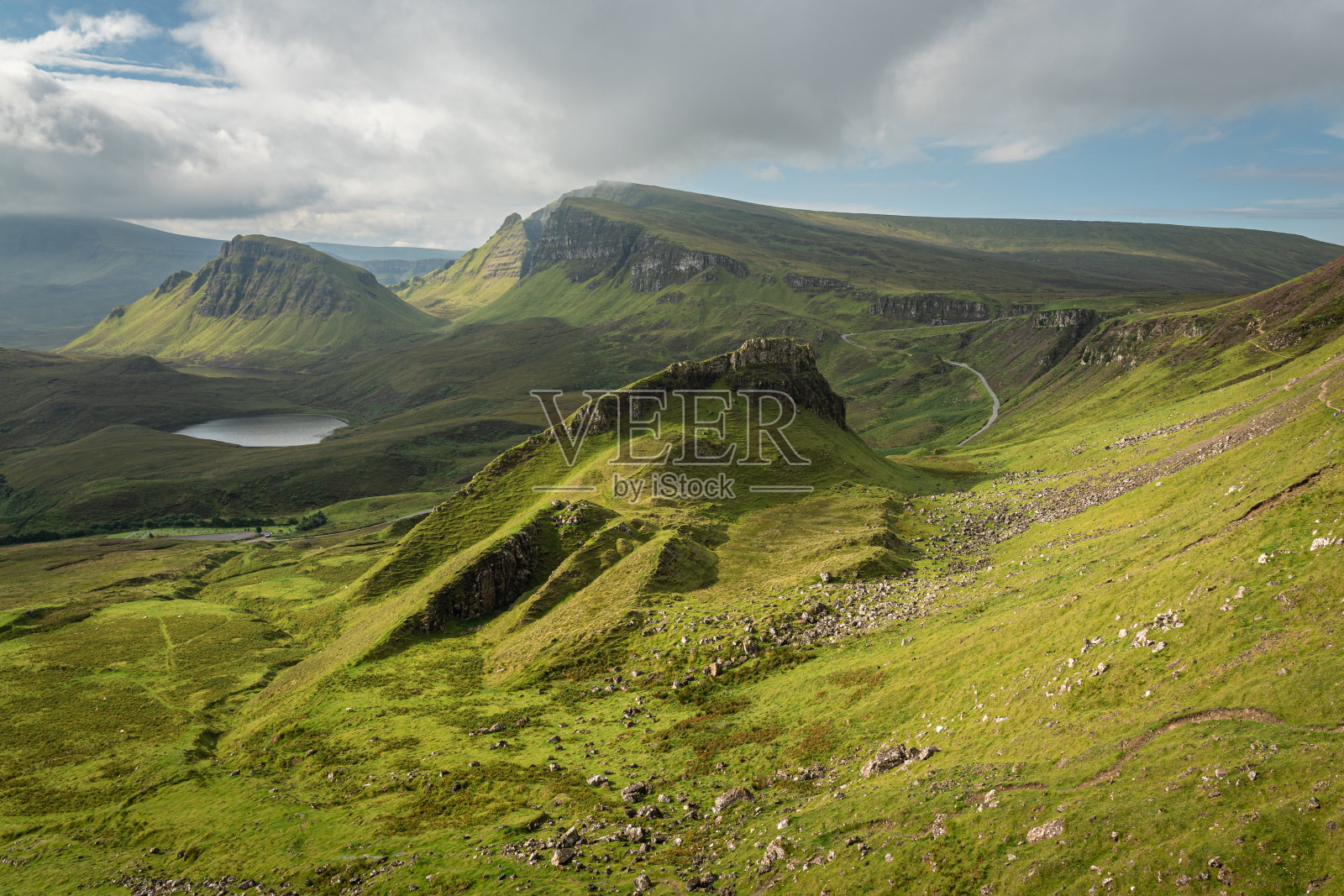 苏格兰斯凯岛奎莱恩的岩层风景。美丽的区域，长满草的山在夏天被盛开的石南覆盖，隐藏的湖和陡峭的悬崖照片摄影图片