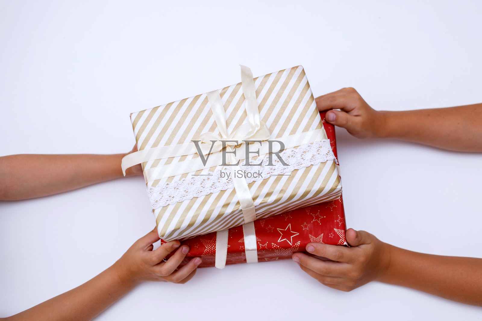 双手牵着两边的两个礼物，红色的包装。照片摄影图片