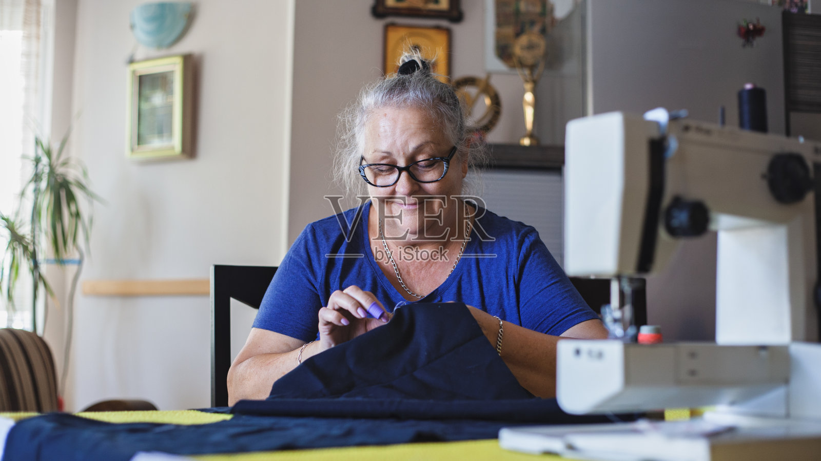 裁缝成熟的女人在家缝制照片摄影图片