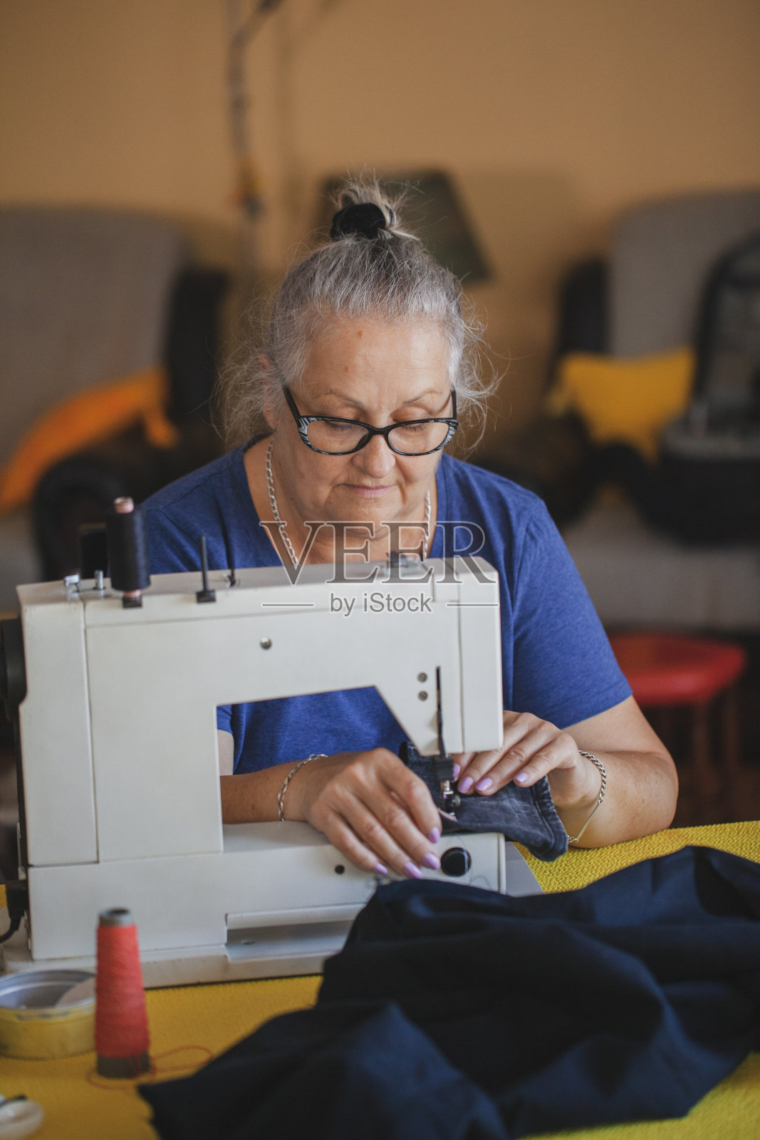 裁缝成熟的女人在家缝制照片摄影图片