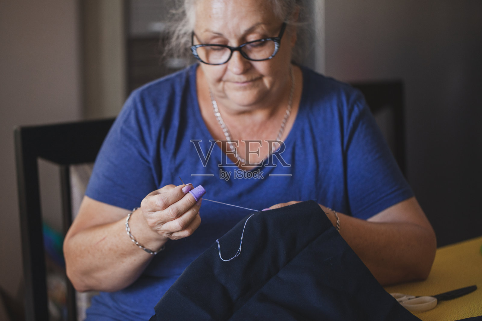 裁缝成熟的女人在家缝制照片摄影图片