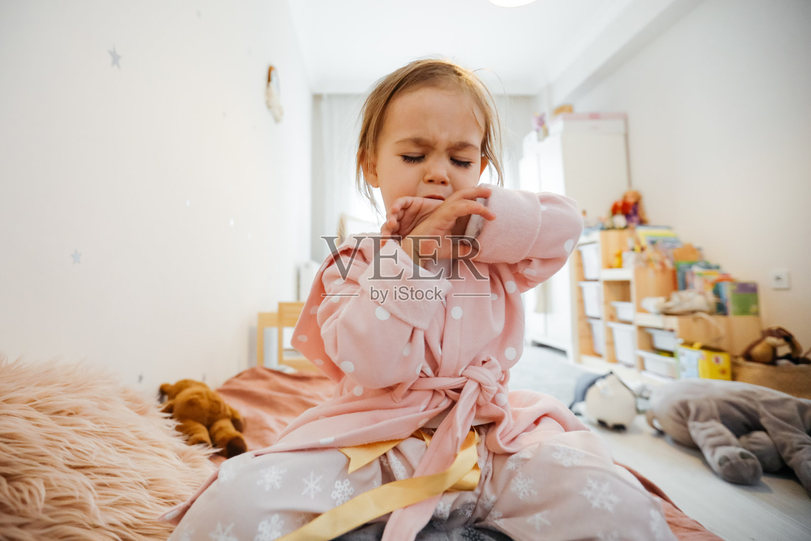 生病的小女孩在床上咳嗽照片摄影图片
