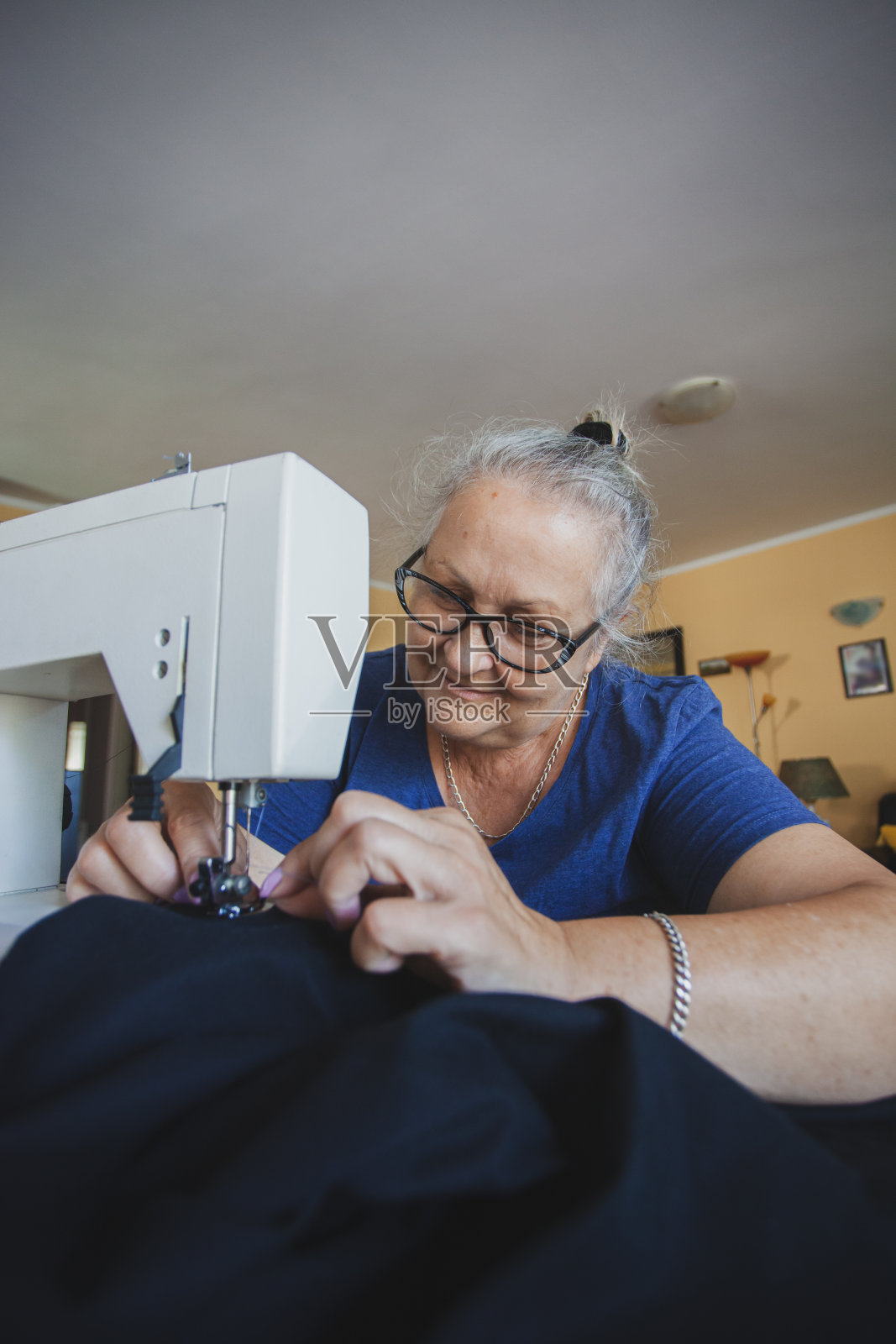 裁缝成熟的女人在家缝制照片摄影图片