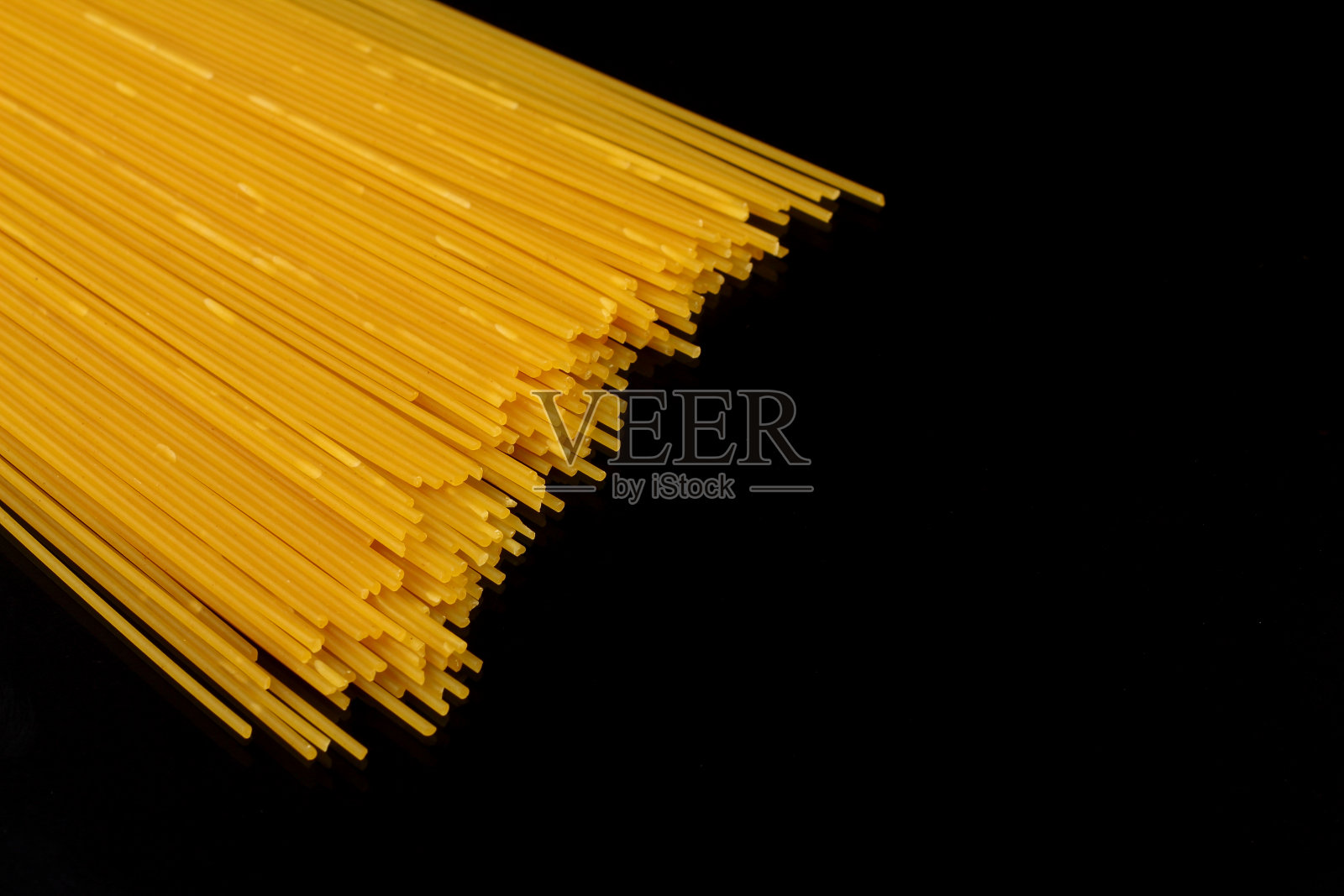 意大利面孤立在黑色背景上。白色的长意大利面。照片摄影图片