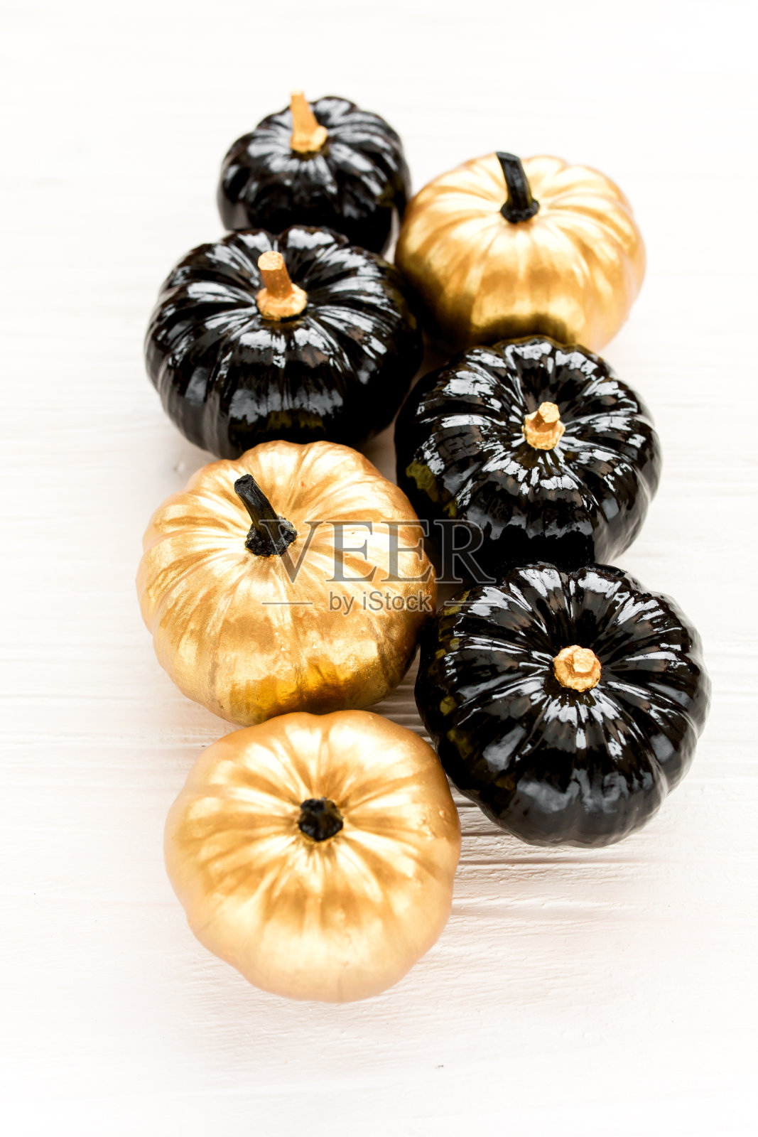 时尚的万圣节装饰品。装饰南瓜黑色和金色万圣节孤立在白色的背景。平躺，俯视图照片摄影图片