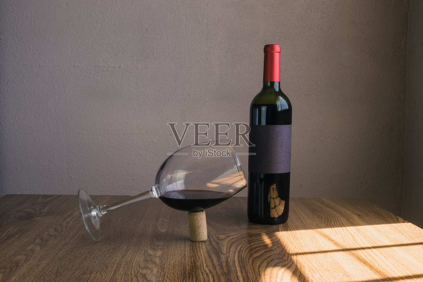 平衡的葡萄酒杯在软木塞旁边的酒瓶。酒瓶模型照片摄影图片