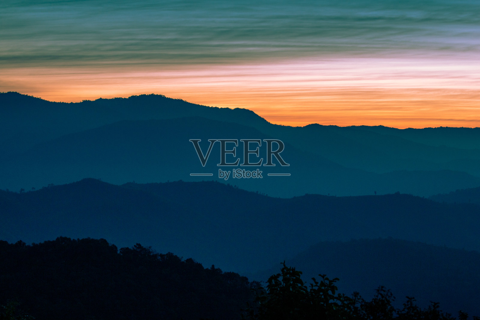 山脉层景观视图。多彩的日出和自然的晨雾。照片摄影图片