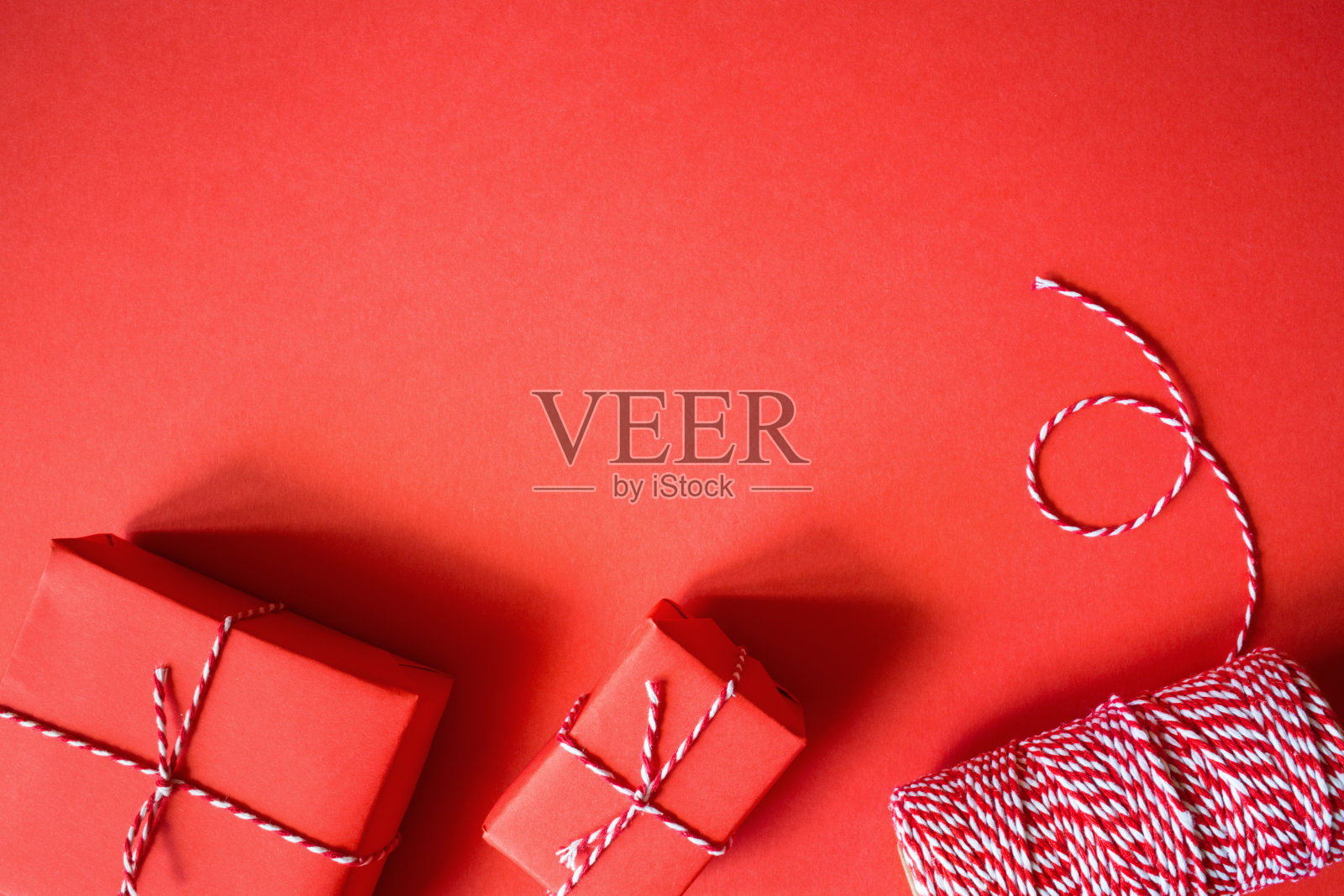 圣诞礼物用红纸包着。新年平铺顶视图背景。模板模拟贺卡。极简主义照片摄影图片