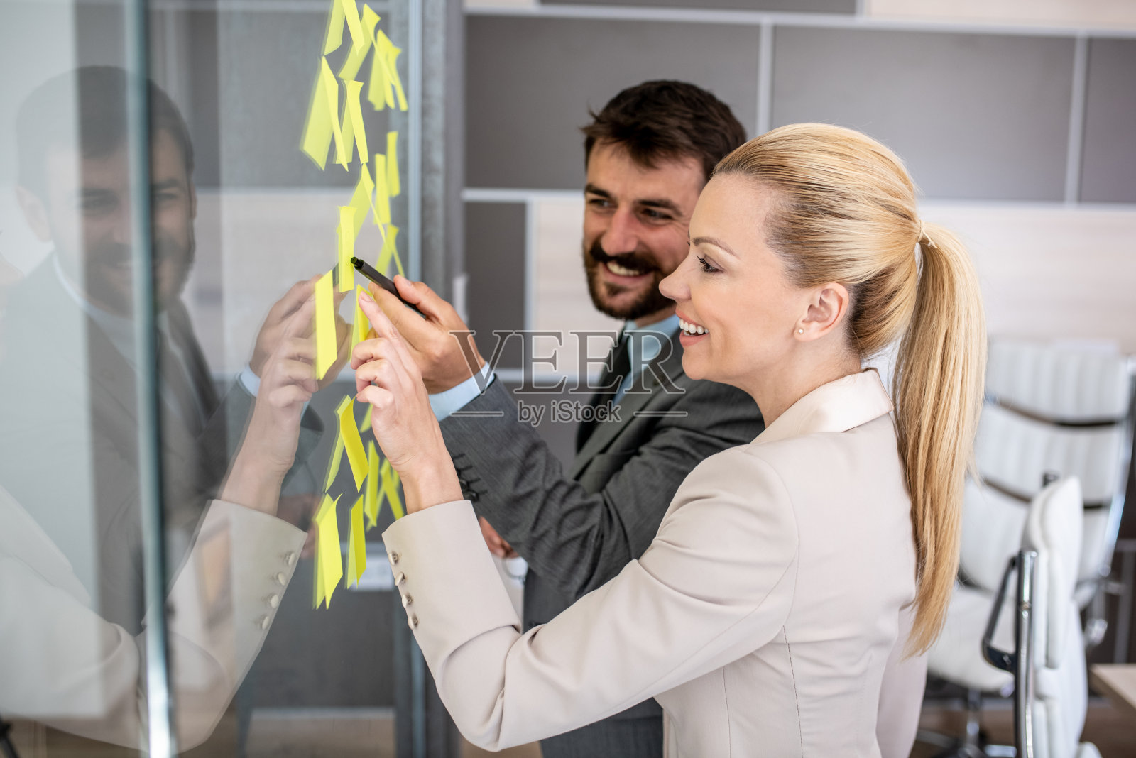 同事们看着他们下周要做的事情，他们都笑了照片摄影图片