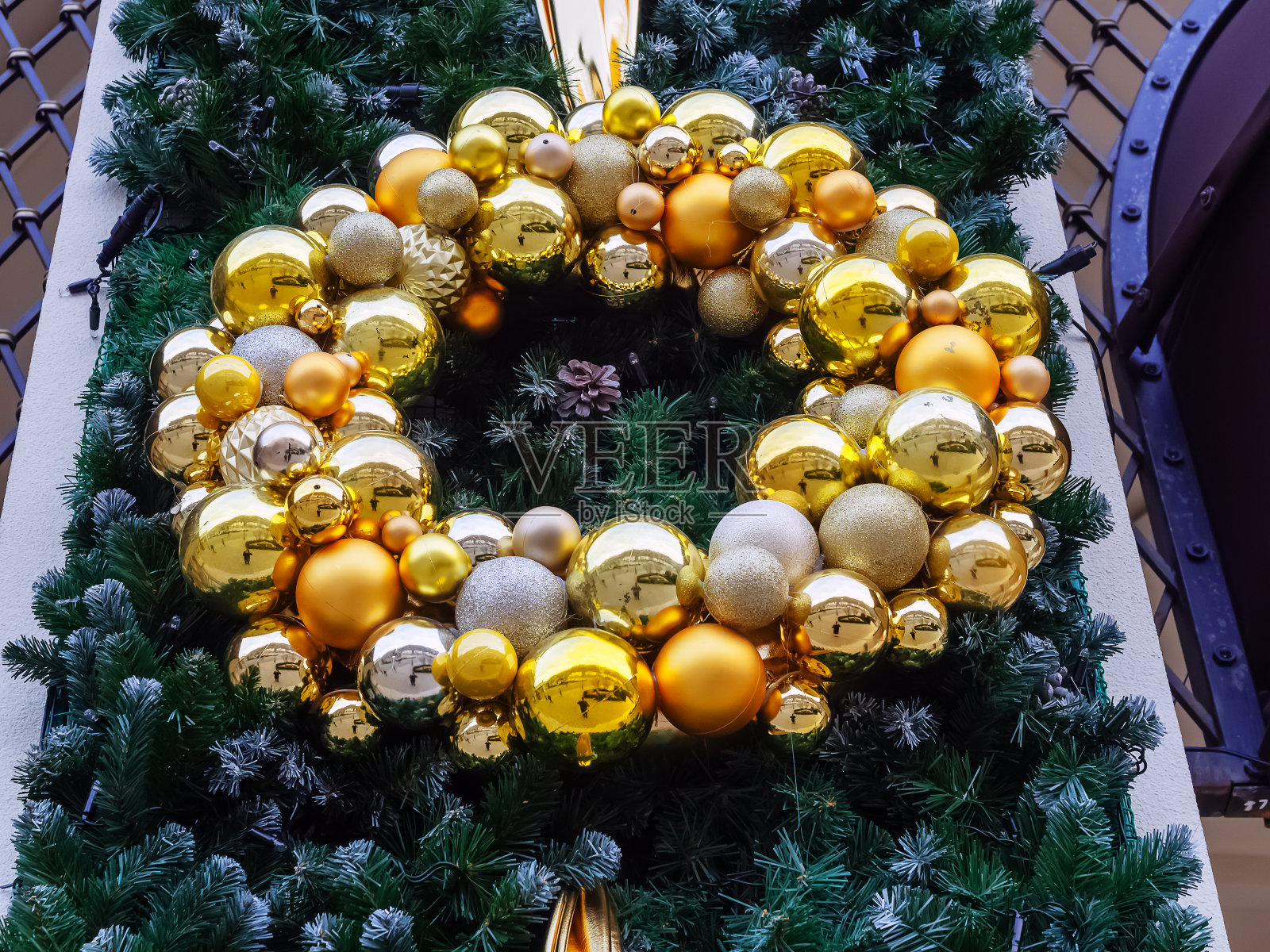 绿色云杉枝上有一圈大小不一的金球。新年的装饰照片摄影图片