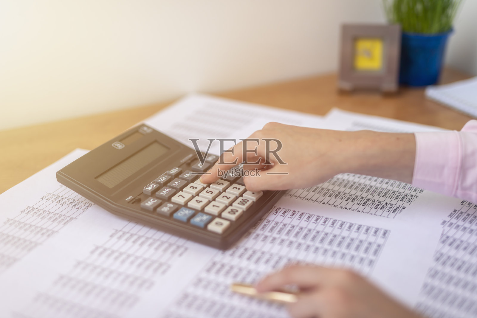 女会计或银行家坐在办公桌前，拿着文件进行计算。储蓄、财务和经济概念照片摄影图片