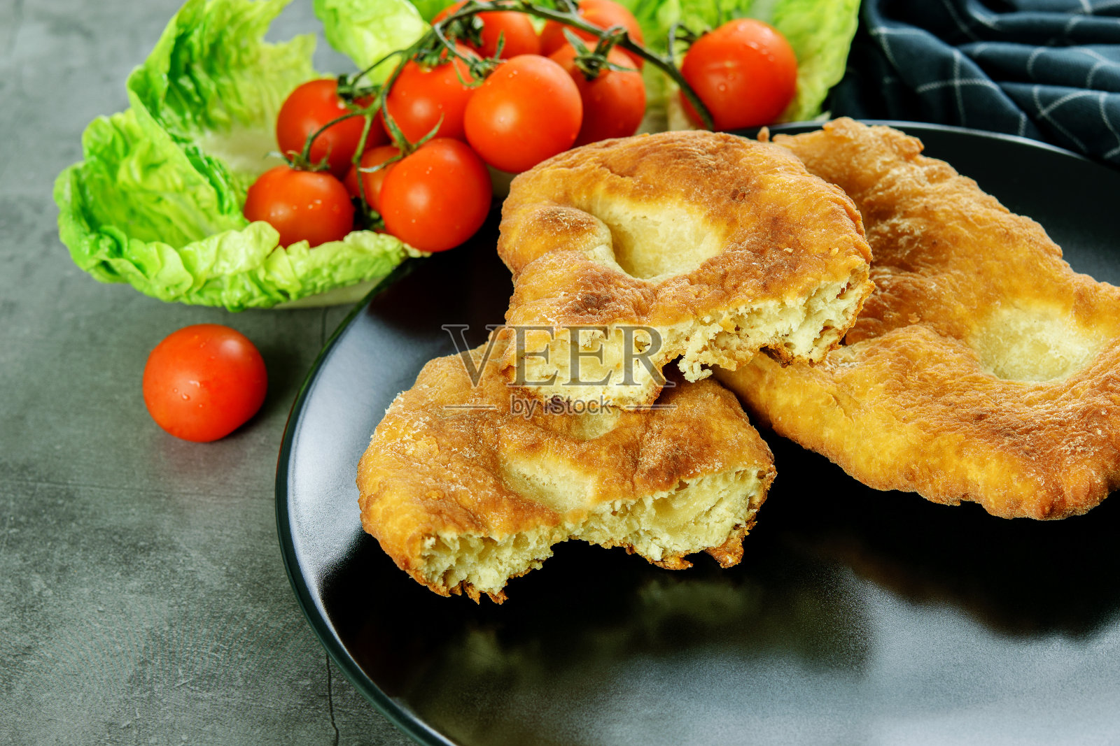 切成薄片的纳瓦霍扁平面包，配上番茄、樱桃和莴苣。照片摄影图片