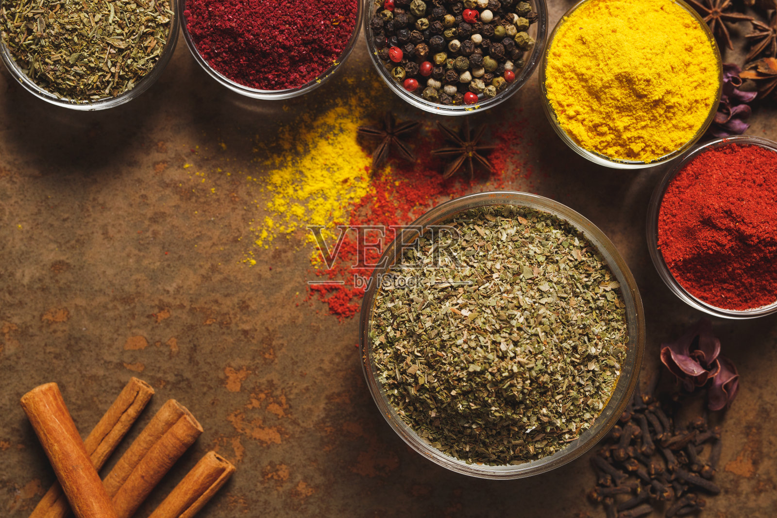 干墨角兰。文本。石头背景上的碗里放着不同种类的香料。从上往下看照片摄影图片