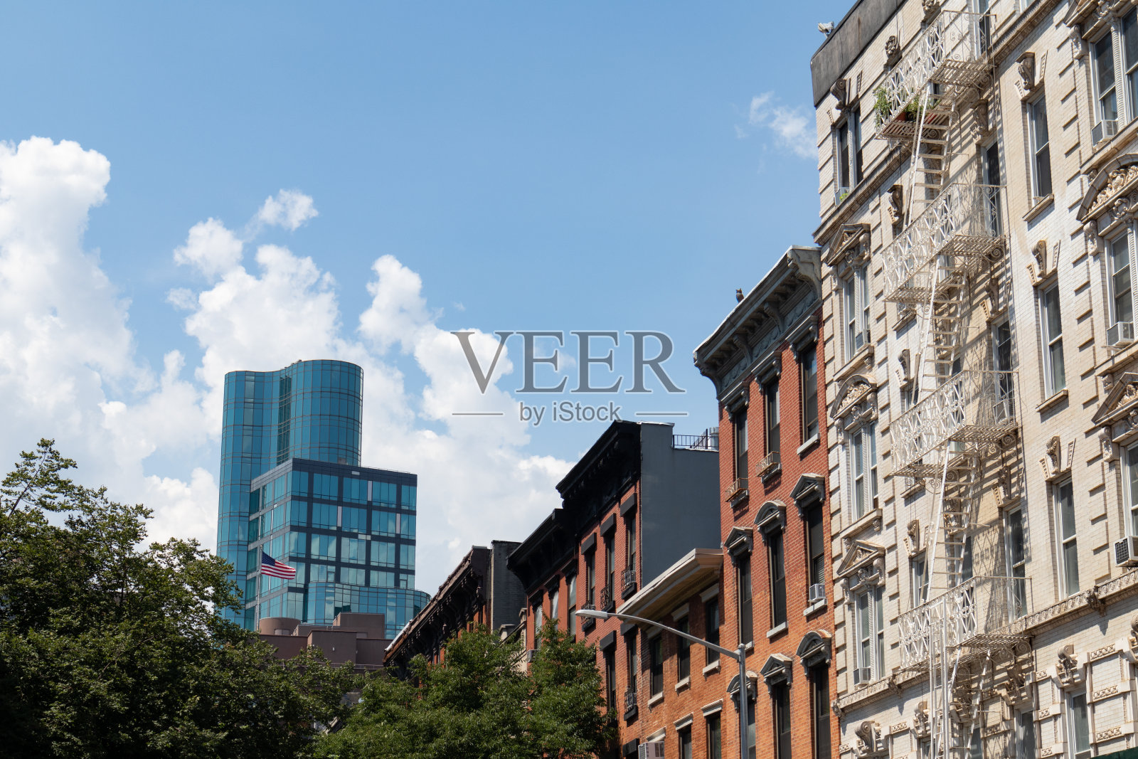 纽约东村一排五颜六色的老住宅楼，有一座现代化的玻璃摩天大楼照片摄影图片