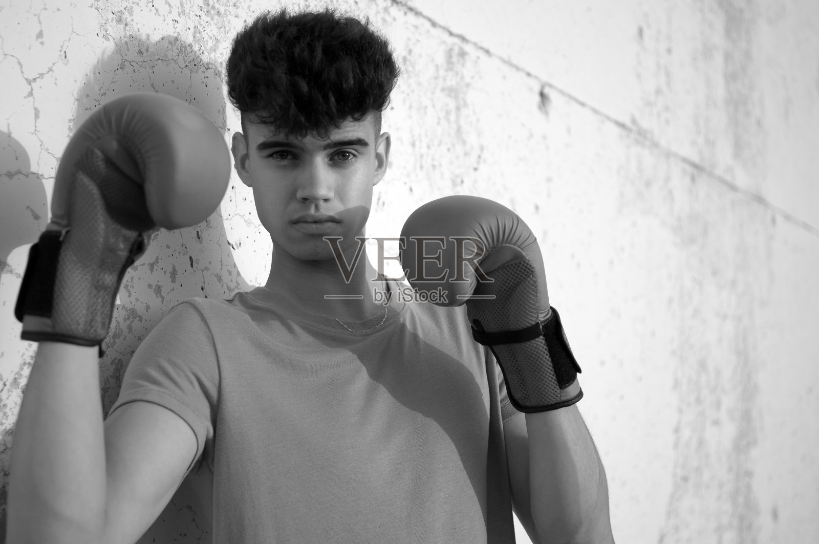 戴拳击手套的年轻人站在防守位置，有拷贝空间。照片摄影图片