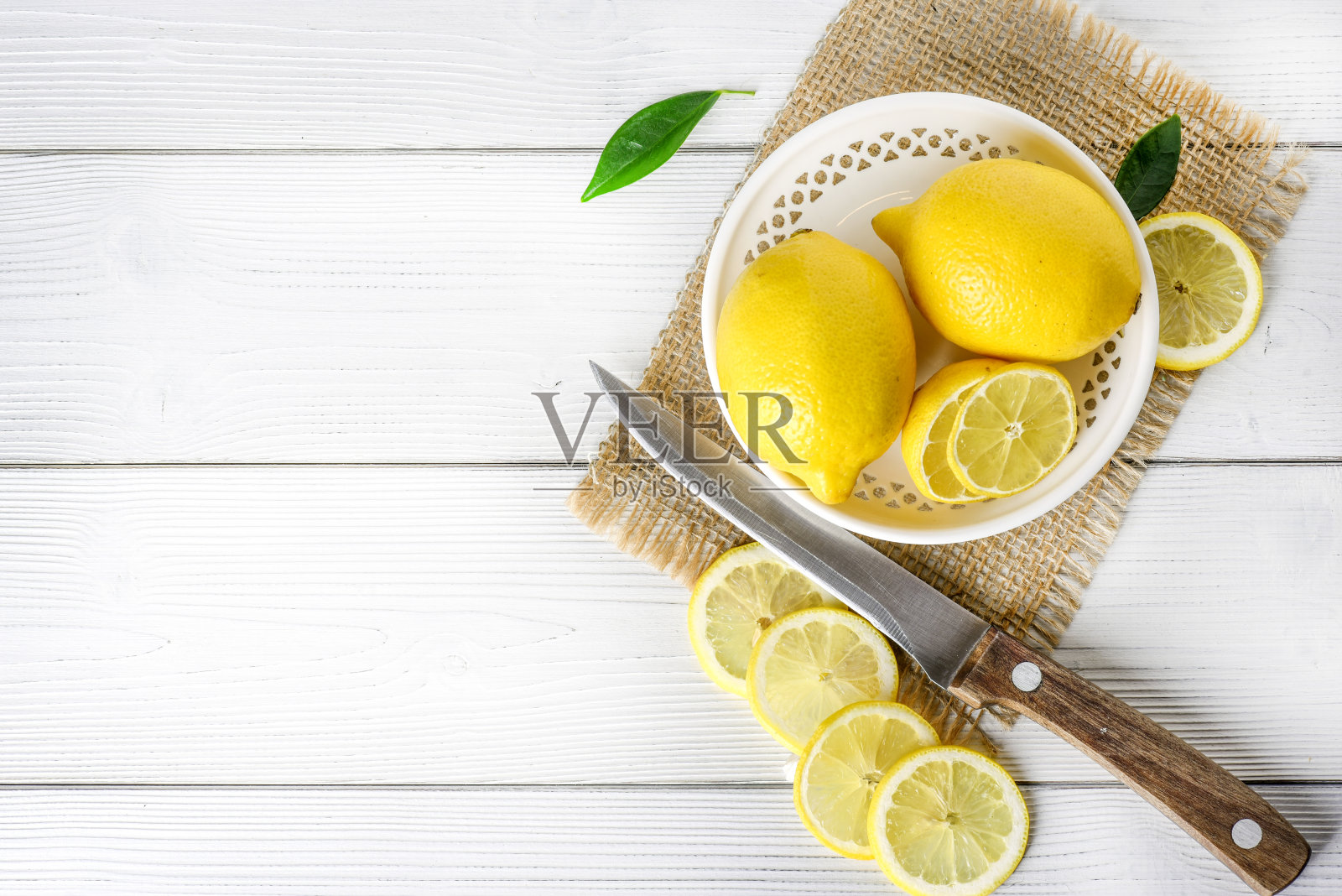 新鲜多汁的柠檬放在白色质朴的桌子上。照片摄影图片