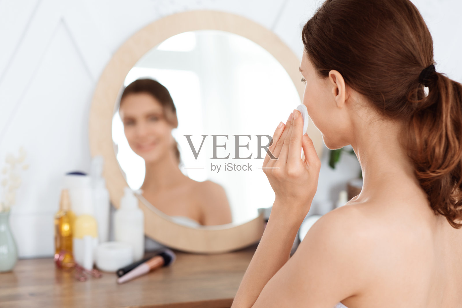 年轻女子在脸上擦爽肤水照片摄影图片