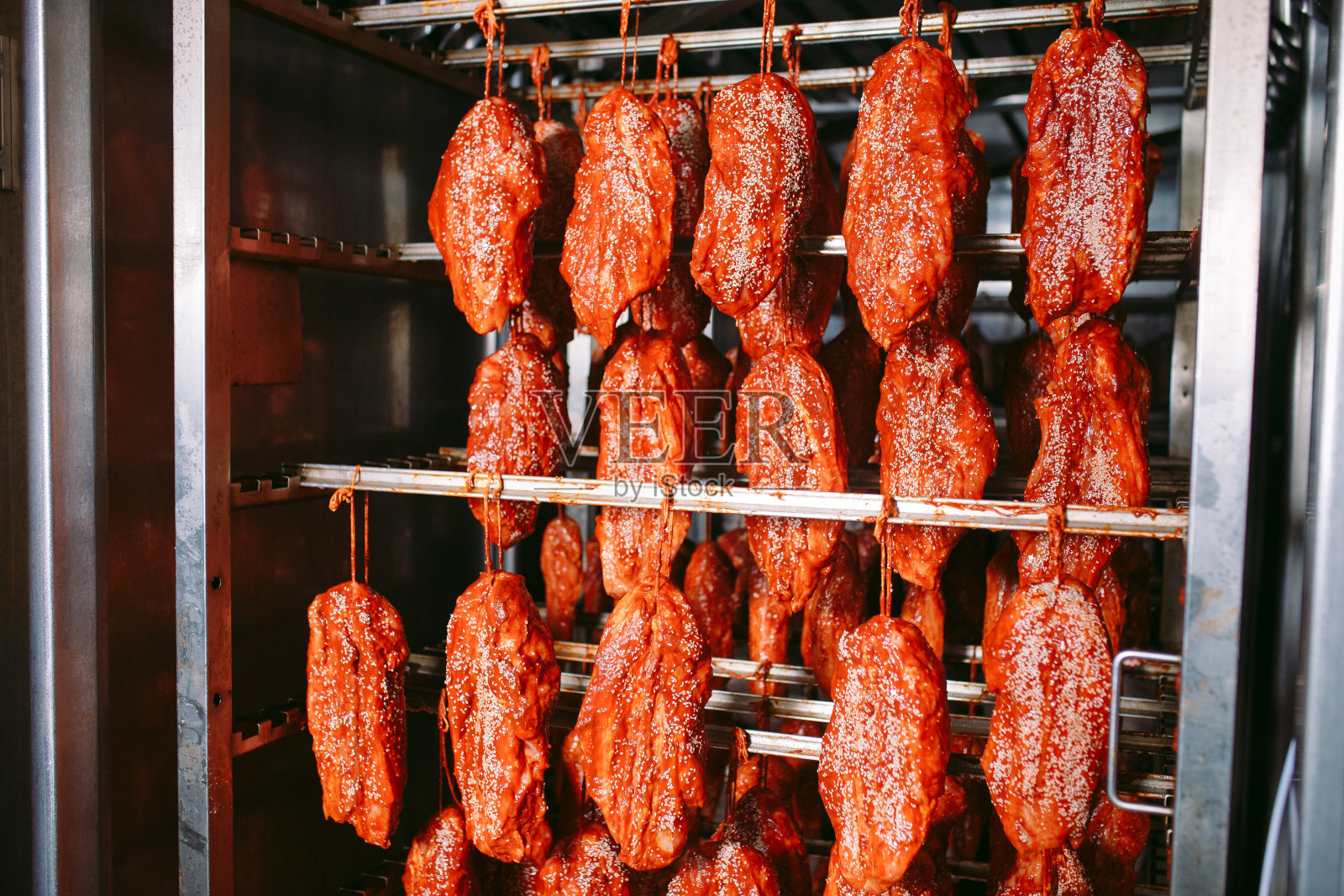 烤箱里的熏火腿。生产香肠的工厂。照片摄影图片