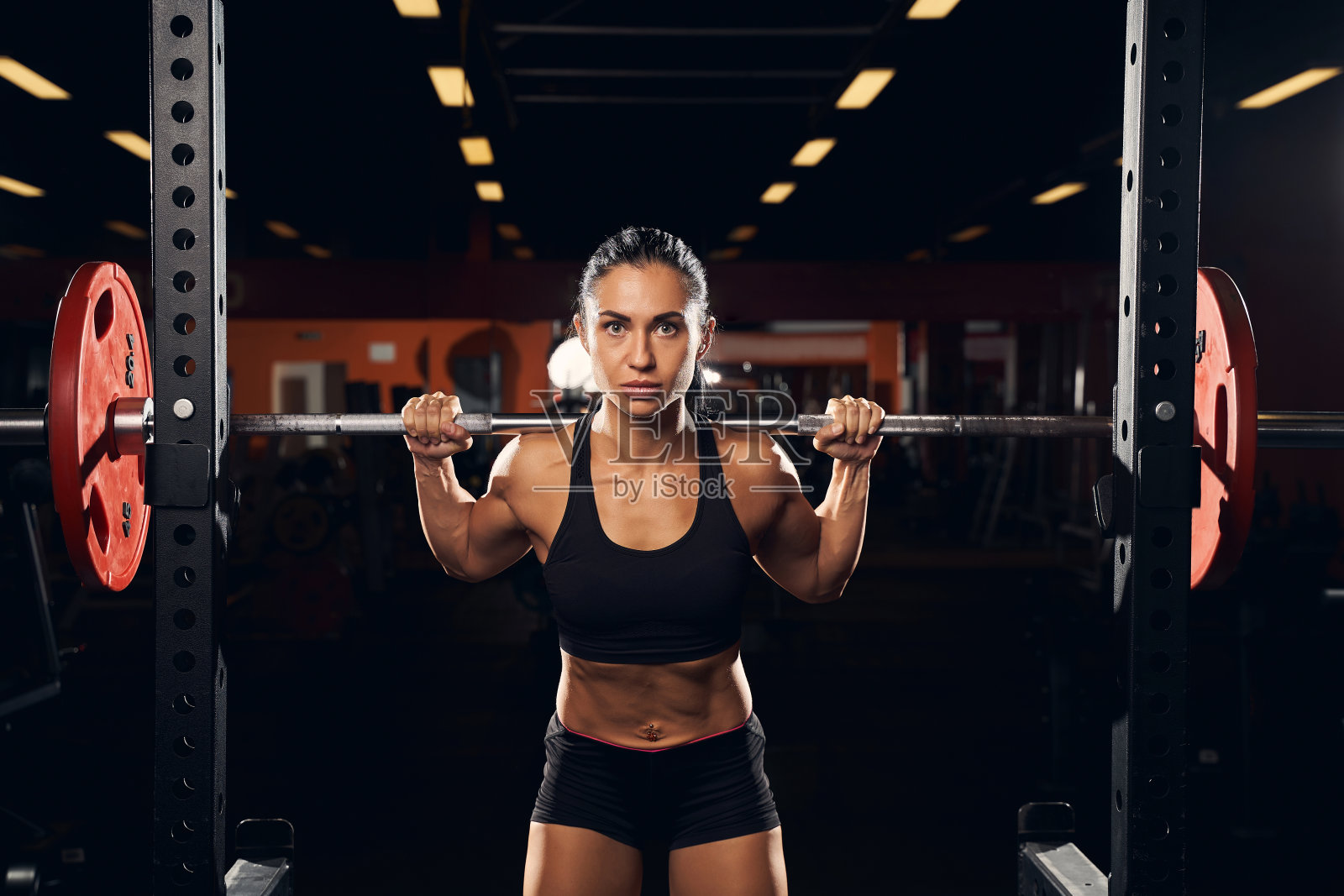 严肃的女运动员用杠铃锻炼照片摄影图片