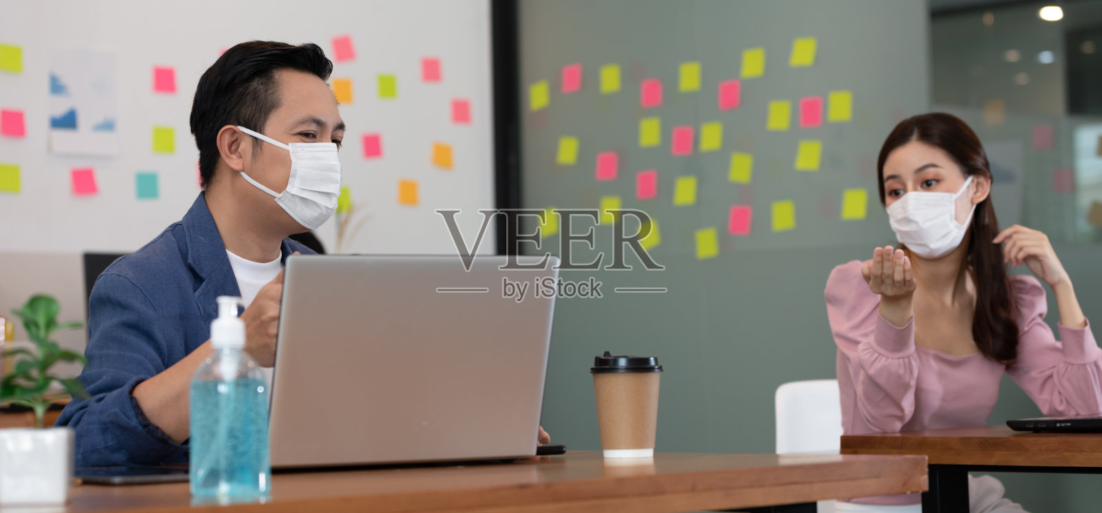 新常态的商务男女戴着口罩开会，在社会距离较远的情况下一起讨论、集思广虑，以获得想法或营销解决方案照片摄影图片