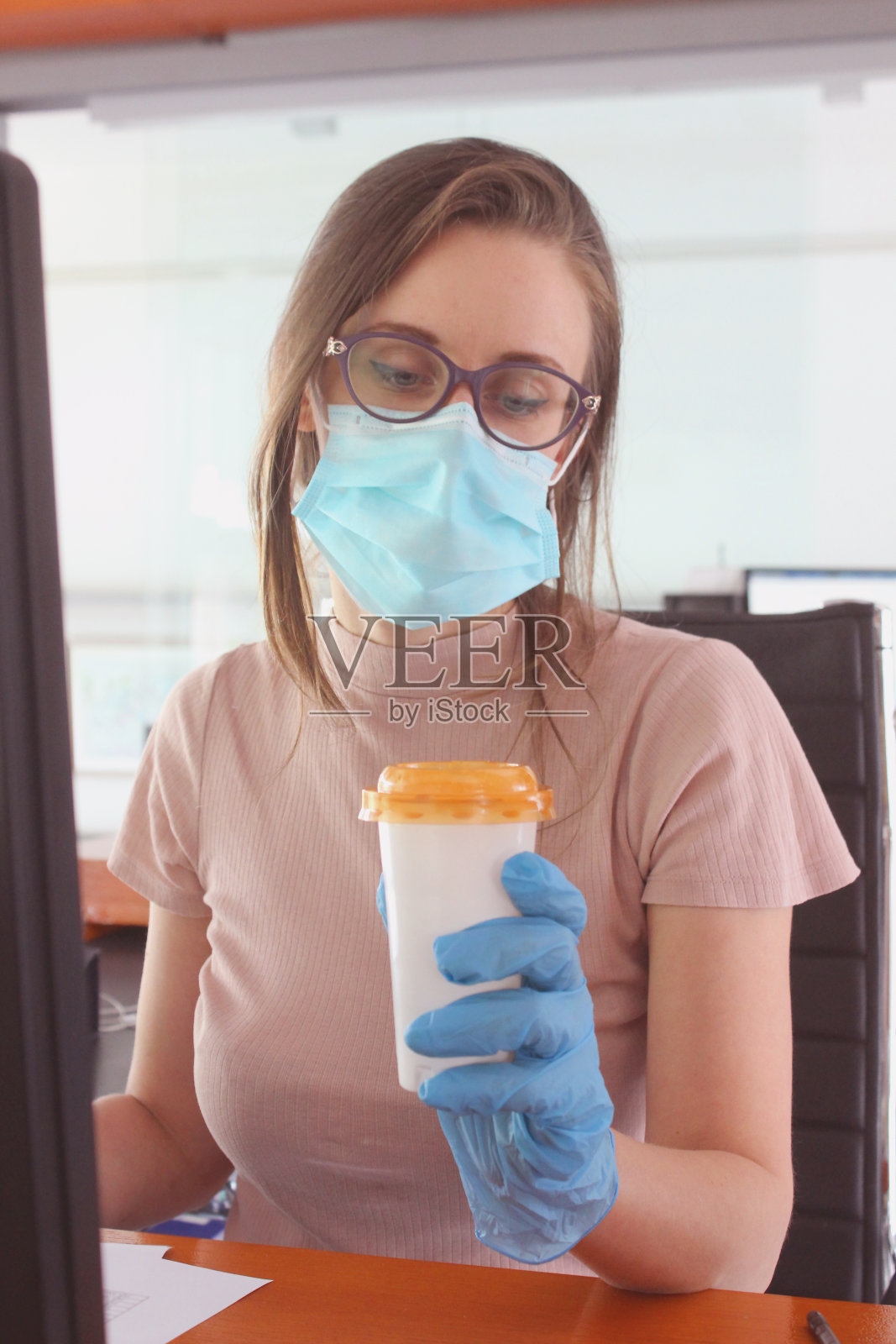 戴着防护口罩喝咖啡的年轻女图书管理员照片摄影图片