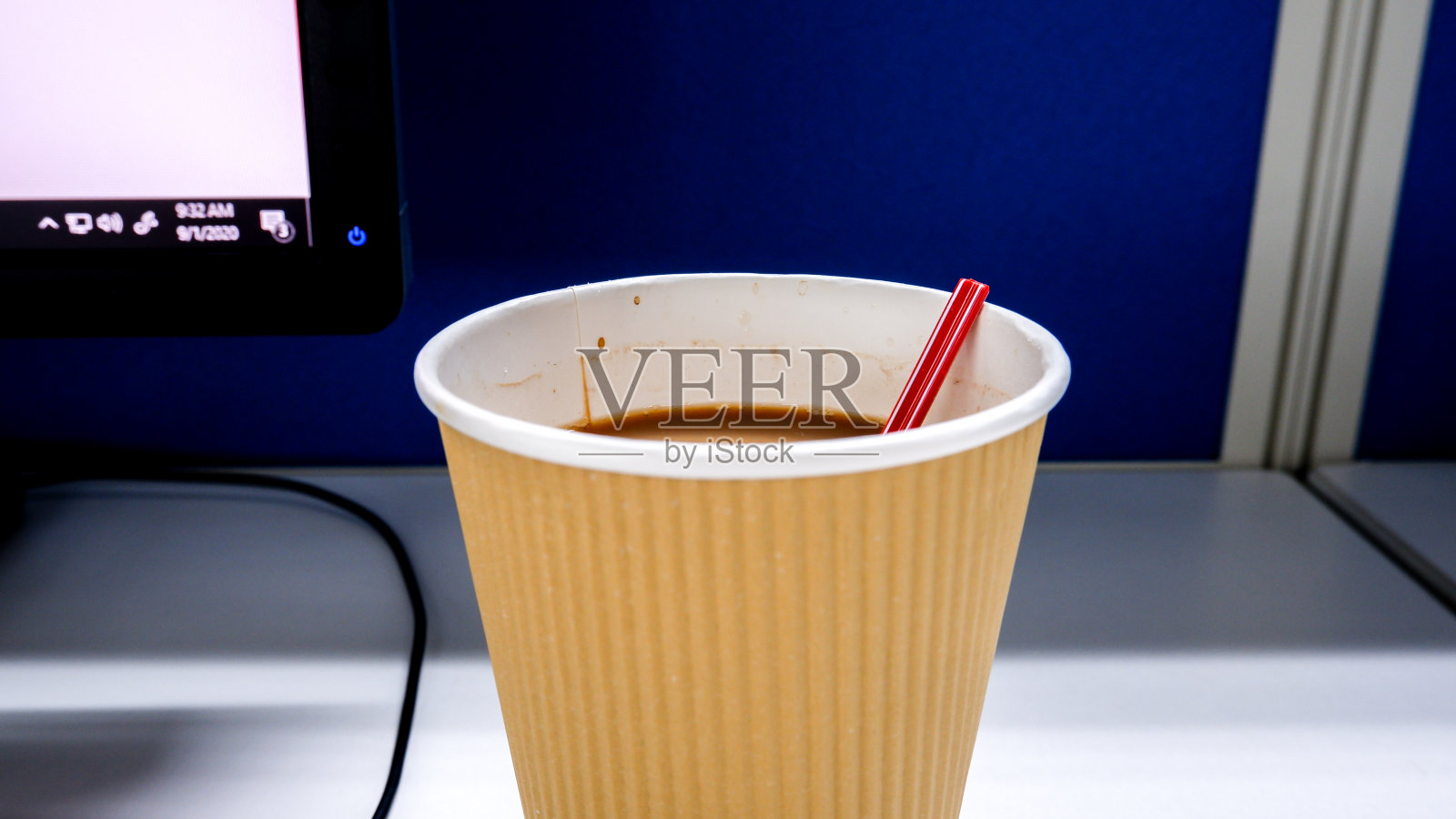 近距离拍摄的一次性杯咖啡搅拌器在办公桌与电脑背景照片摄影图片