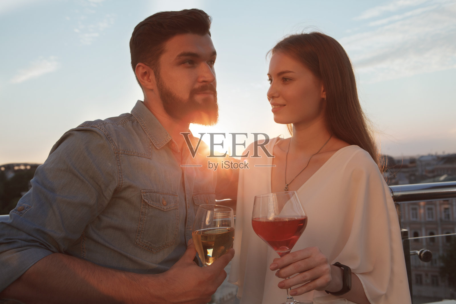 一对情侣在天台约会喝酒照片摄影图片