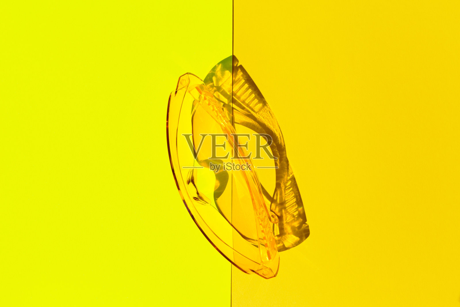 黄色背景上的透明有色眼镜。创造性的单色布局。照片摄影图片