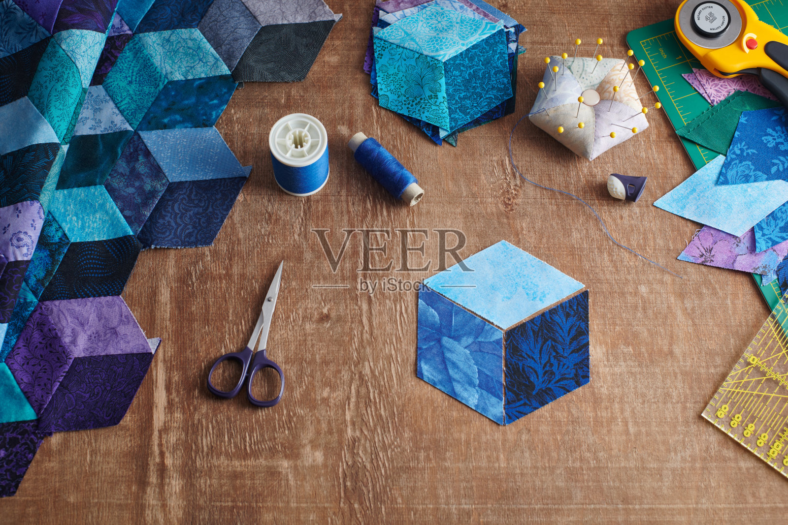 滚块棉被的碎片，用于在木质表面上绗缝的配件。照片摄影图片