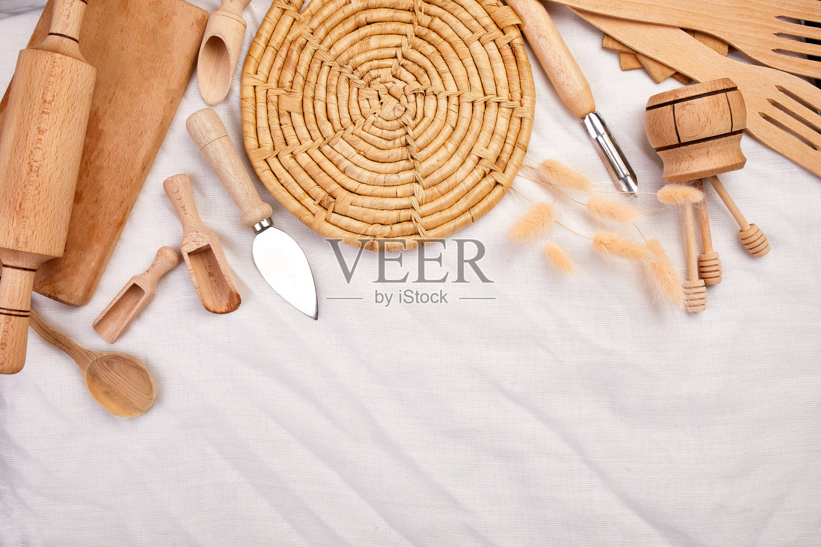 以纺织品为背景，平铺木质厨房用具、烹饪工具照片摄影图片