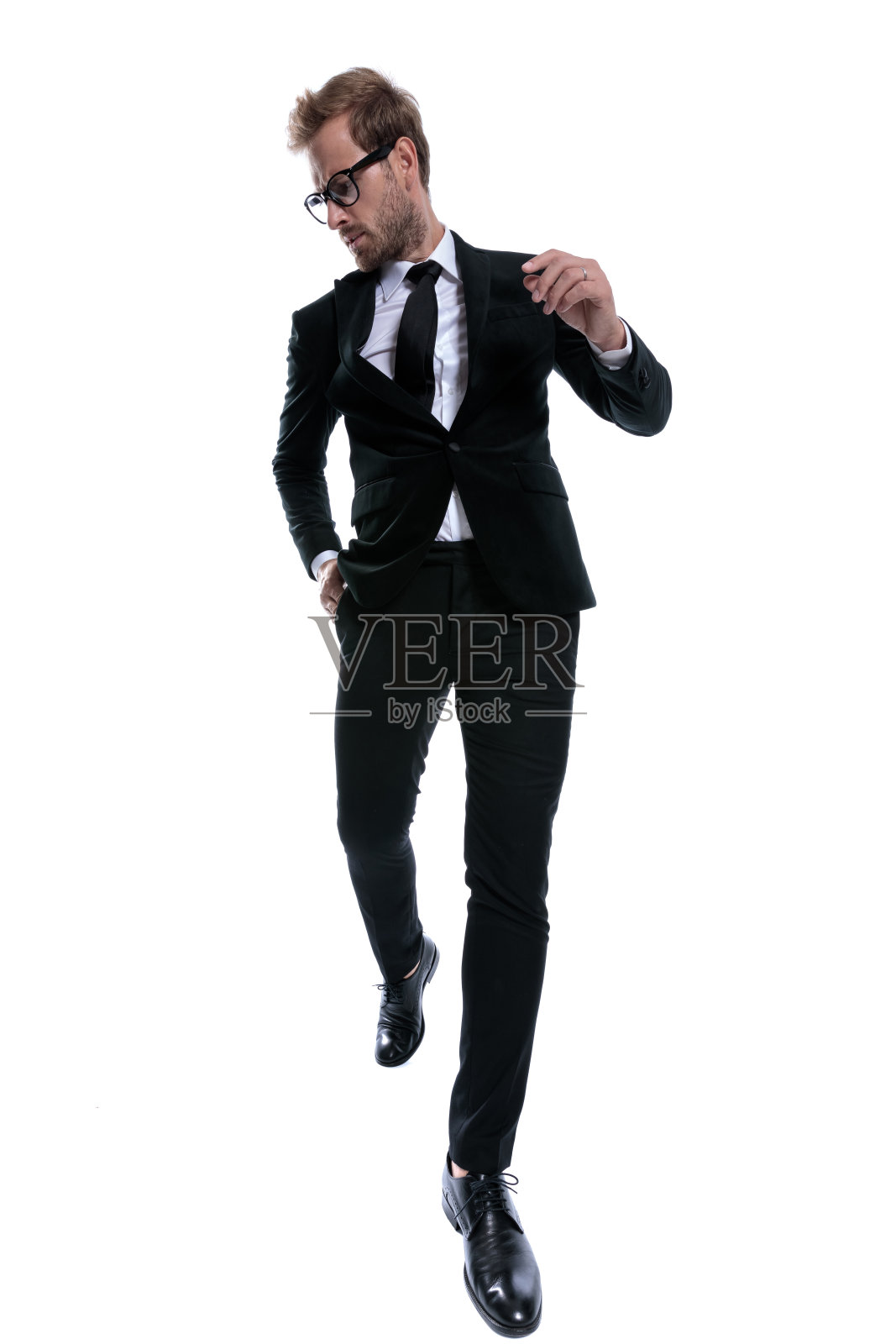 时尚优雅的男子在黑色西装往下看照片摄影图片