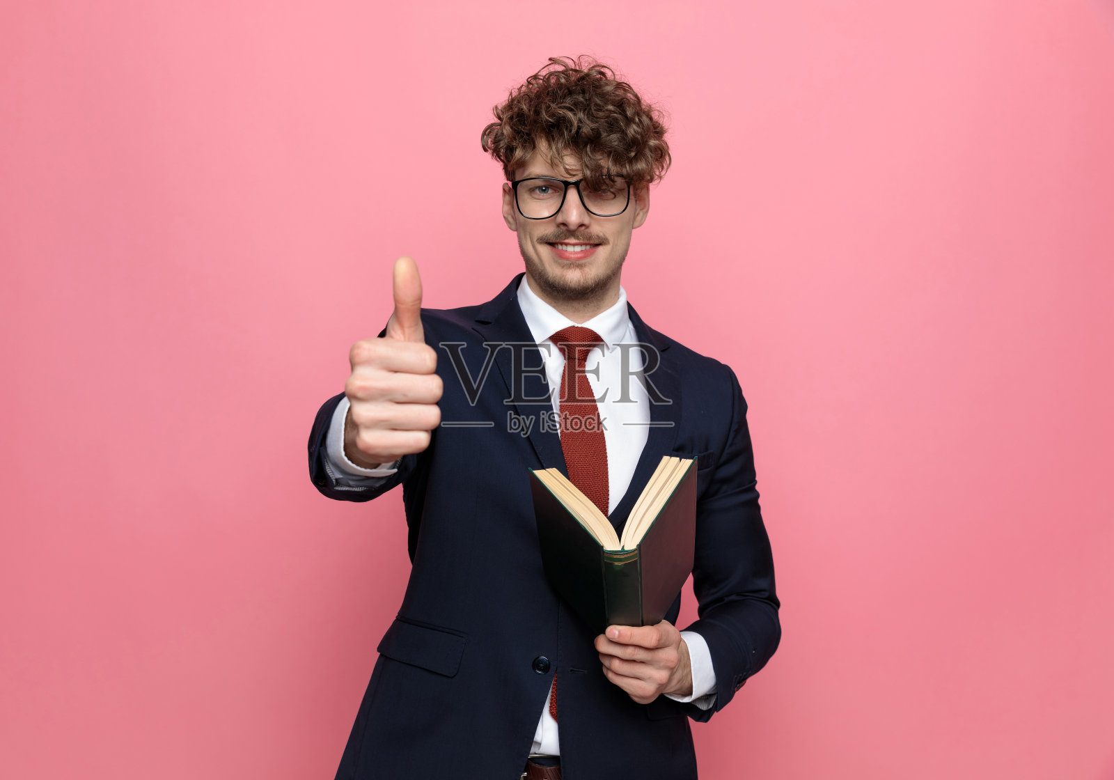 优雅的年轻商人一边看书一边竖起大拇指照片摄影图片