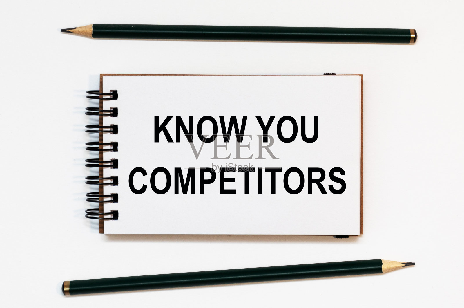 白色螺旋笔记本，两支铅笔用文字知道你的竞争对手照片摄影图片