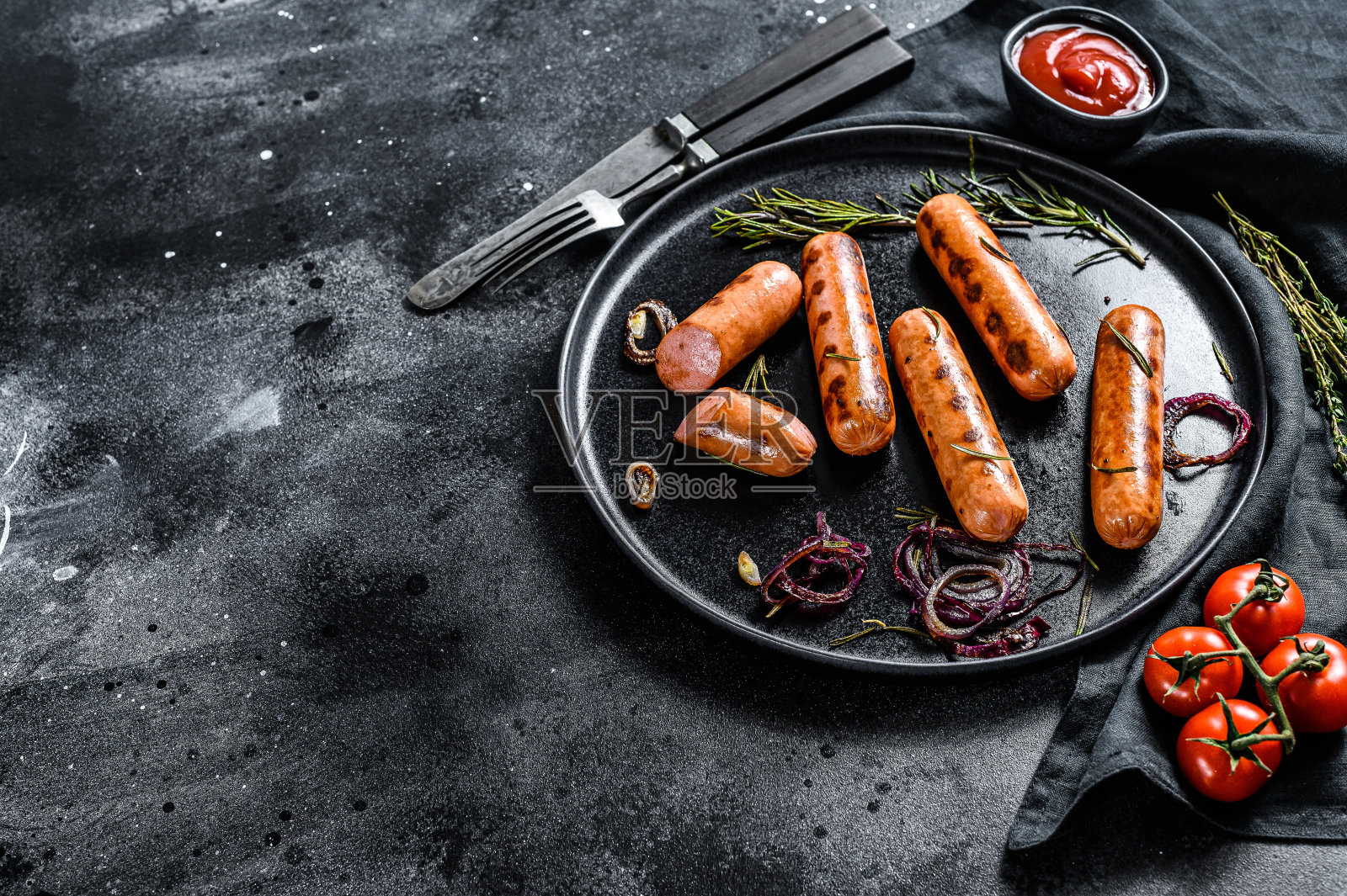 洋葱、大蒜和迷迭香炸鸡香肠。黑色背景。前视图。本空间照片摄影图片