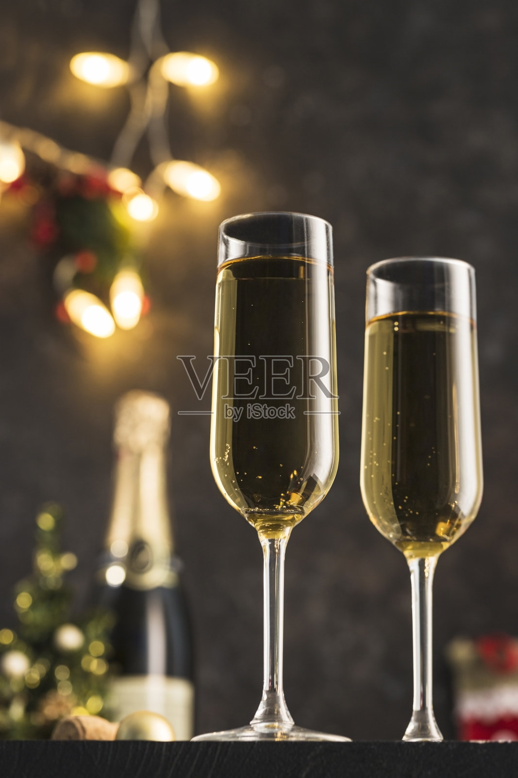 2021年新年——深色背景上的两杯香槟，花环上的焦糖。照片摄影图片