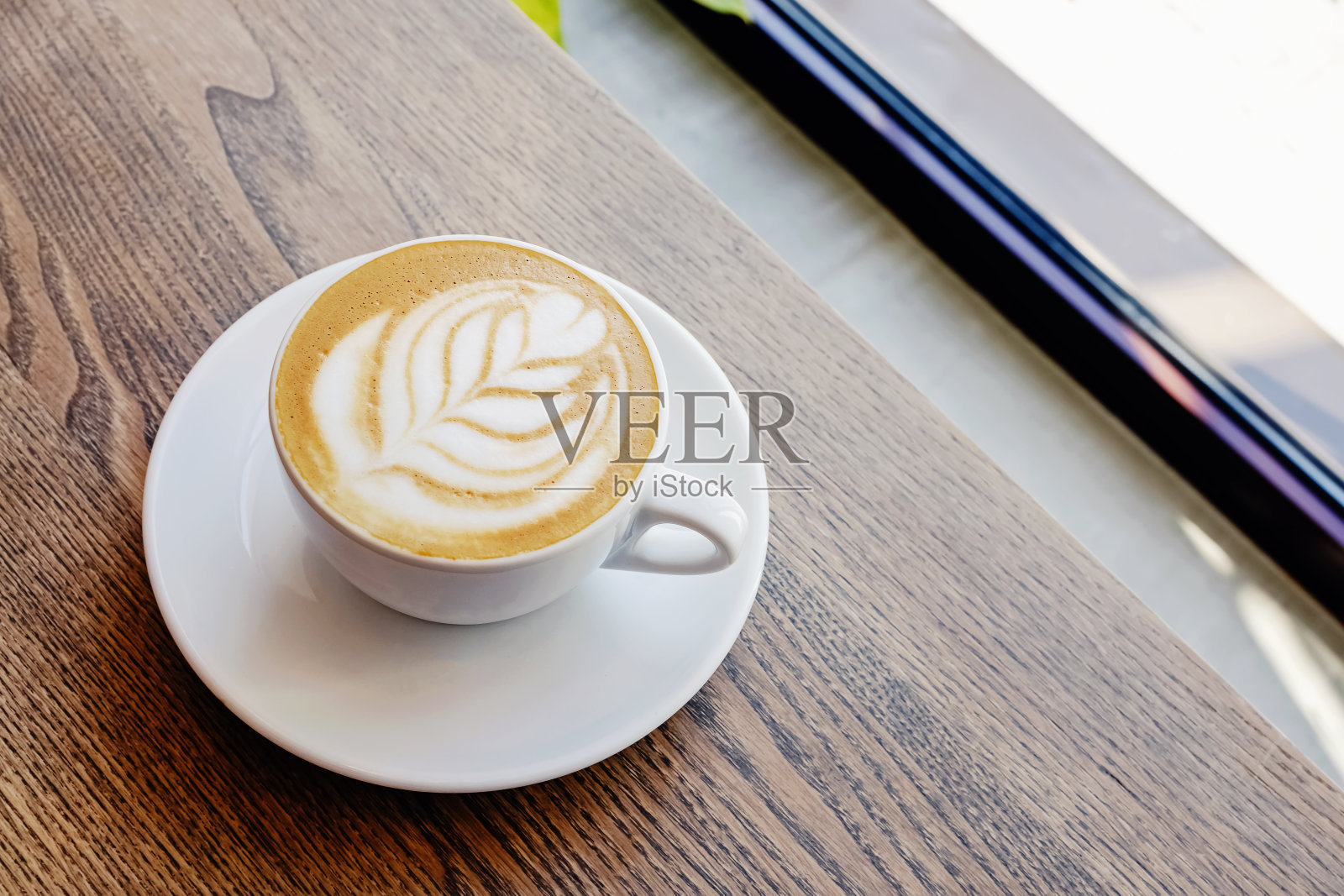 卡布奇诺咖啡在木桌上留下拉花艺术的形状照片摄影图片